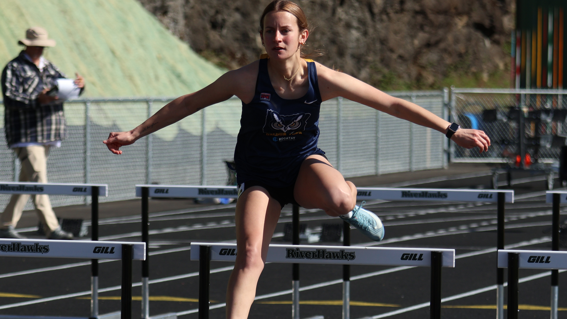 Madi Perkins clearing a hurdle in track
