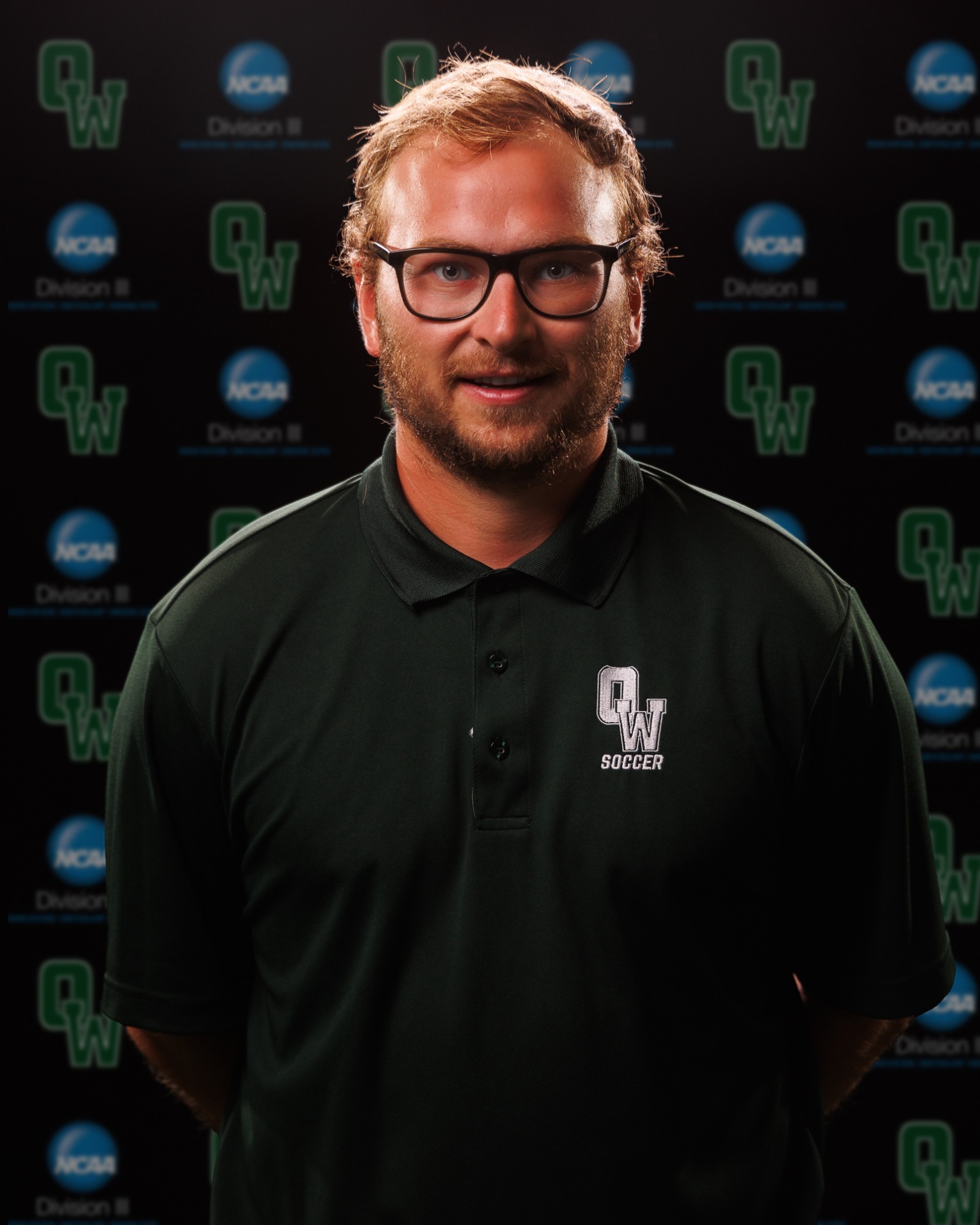 Assistant Coach Strout with arms behind his back