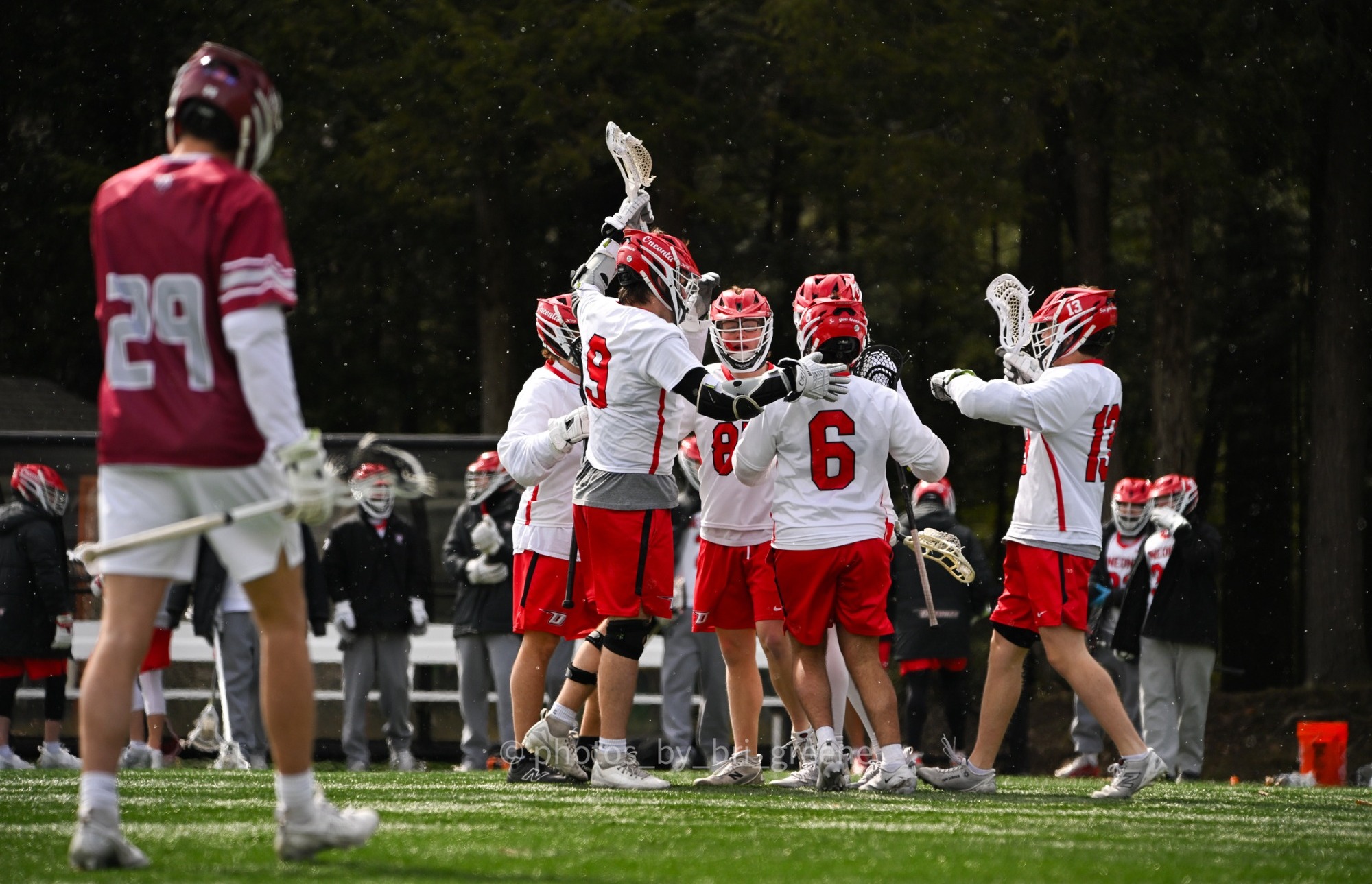 A group of Oneonta men's lacrosse players celebrate scoring the game-winning goal against Potsdam
