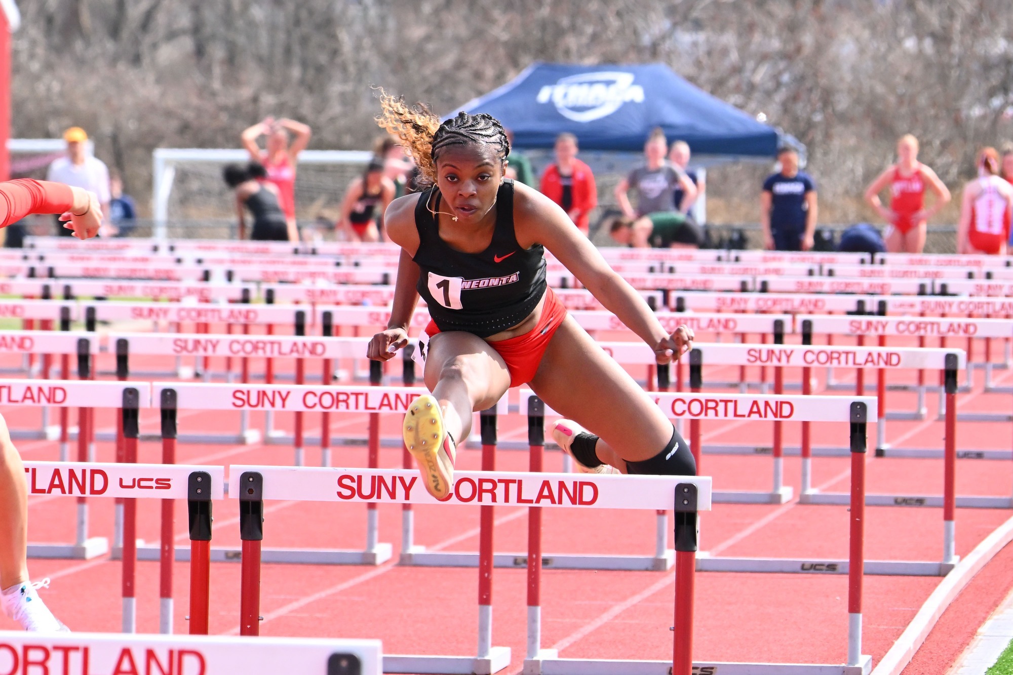Eko Dodd-Brown jumping over a hurdle in the 100-meter hurdle dash at the Cortland Red Dragon Open