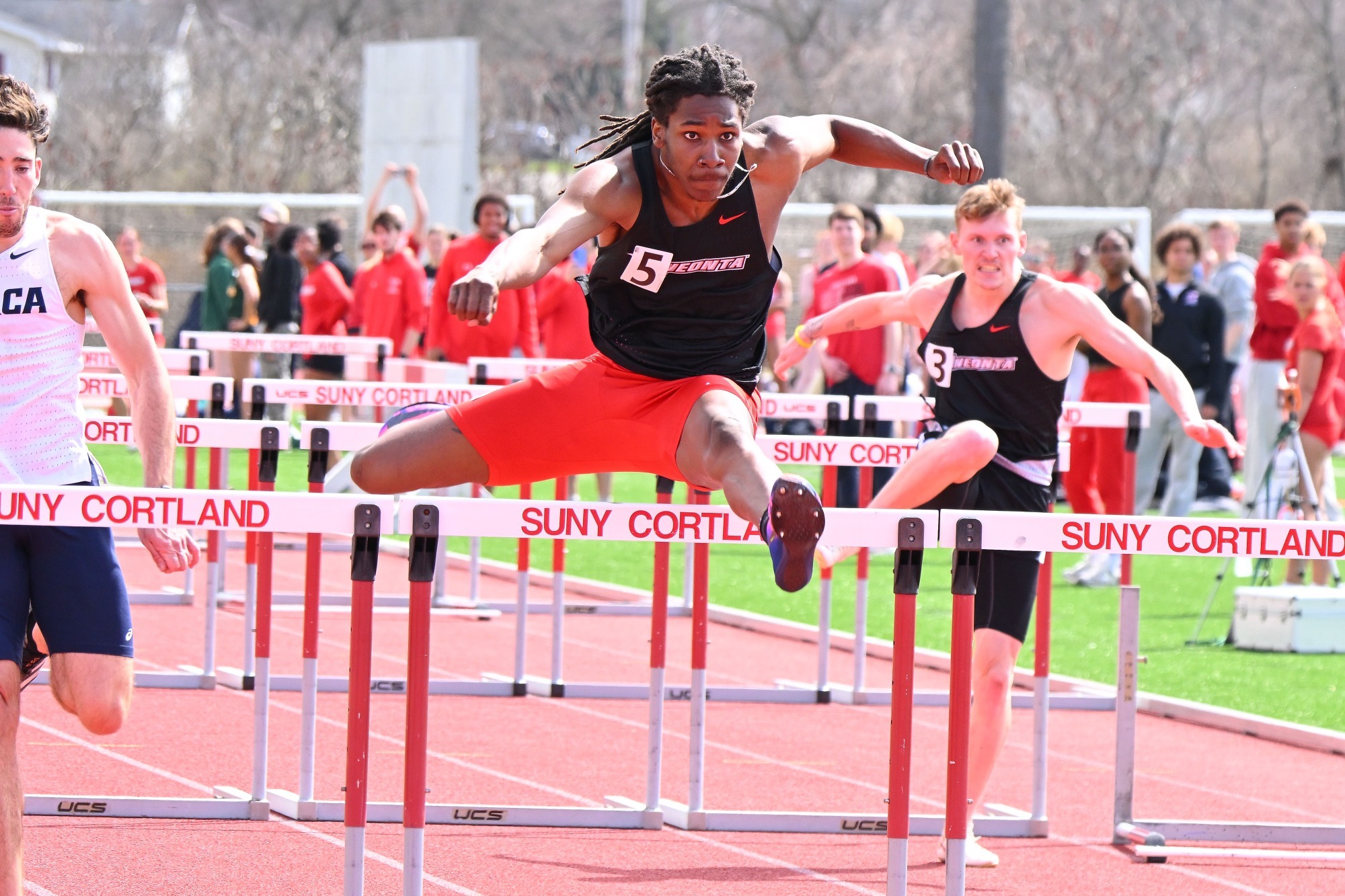 Tariq Earl jumping over a hurdle in the 110-meter hurdle dash at the Cortland Red Dragon Open