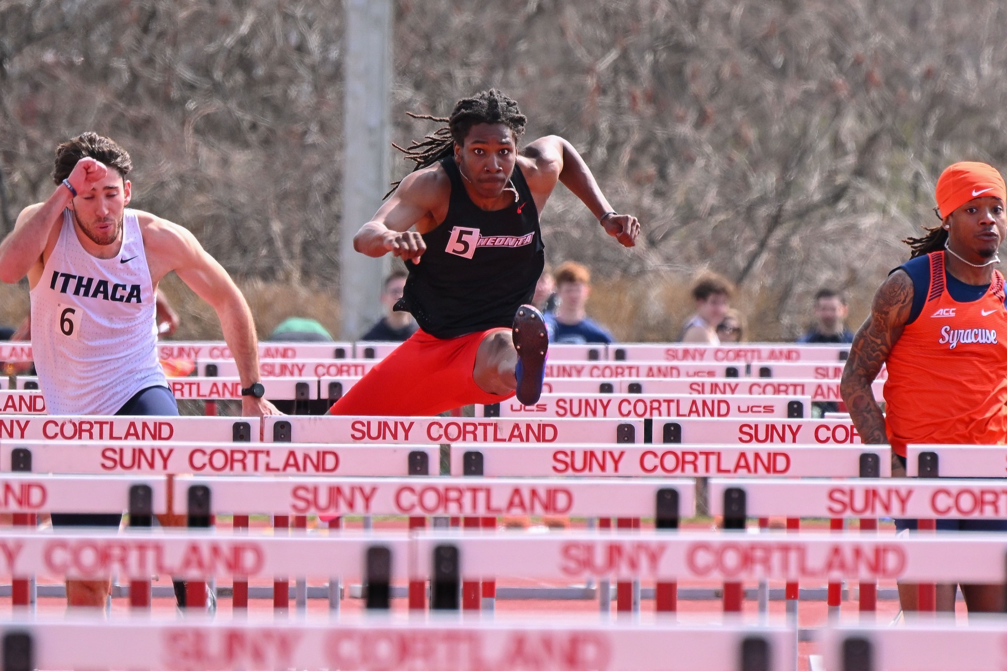 Tariq Earl jumping over a hurdle in the 110-meter hurdle dash at the Cortland Red Dragon Open