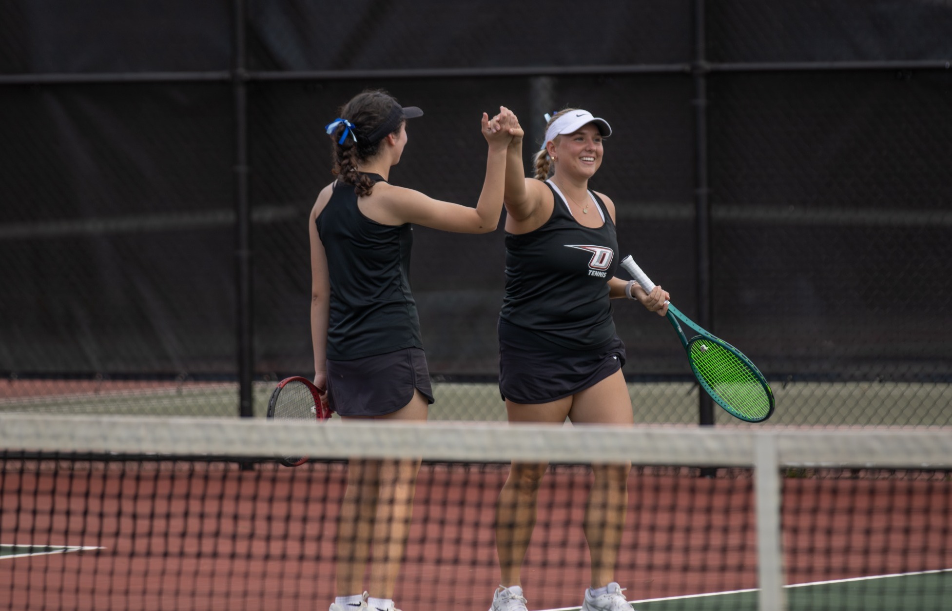 Haley Peck and Dakota Jimenez high five after defeating their Delhi opponents in doubles play