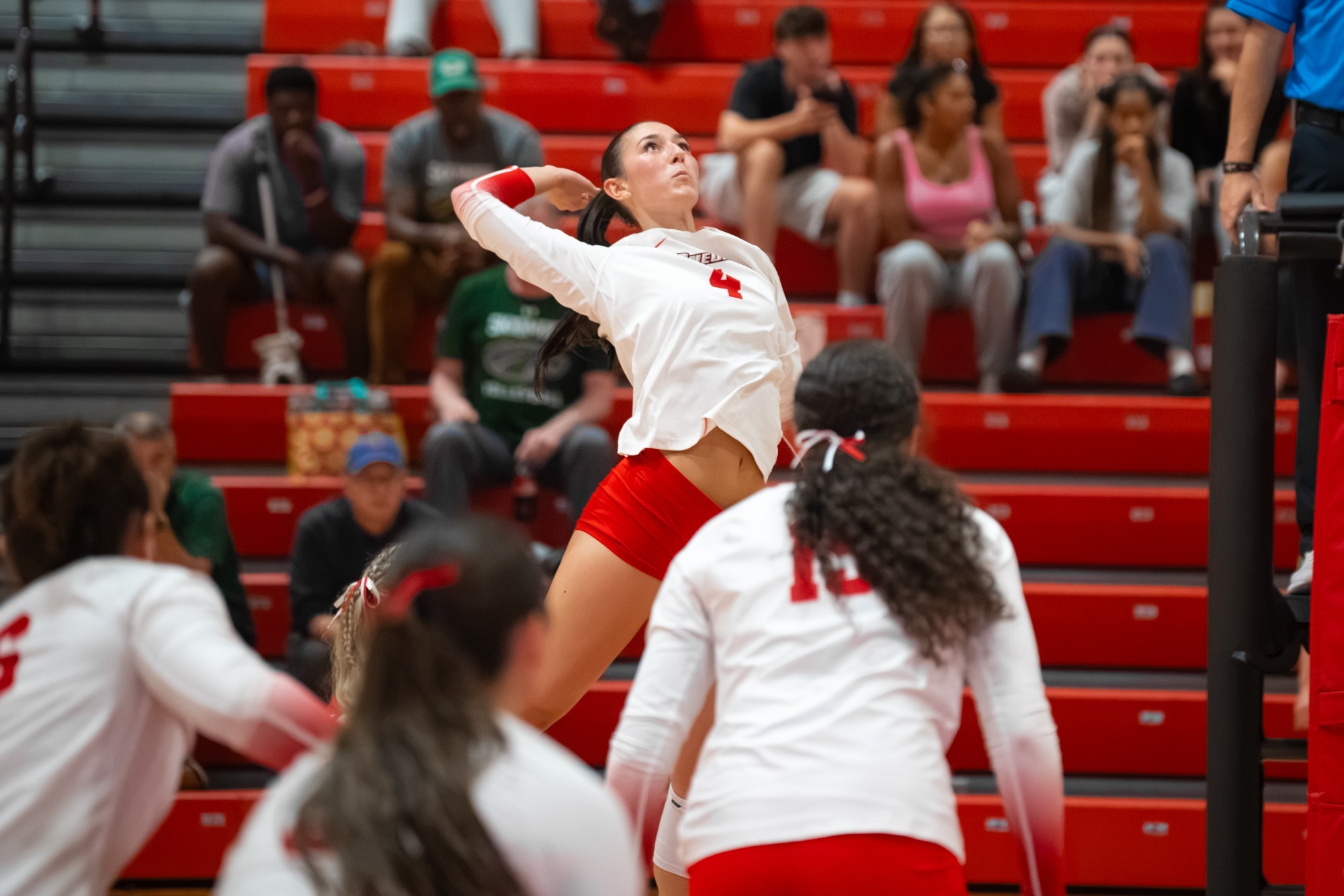 Corynna Manjos jumping and winding back with her right arm preparing to swing for an attack.