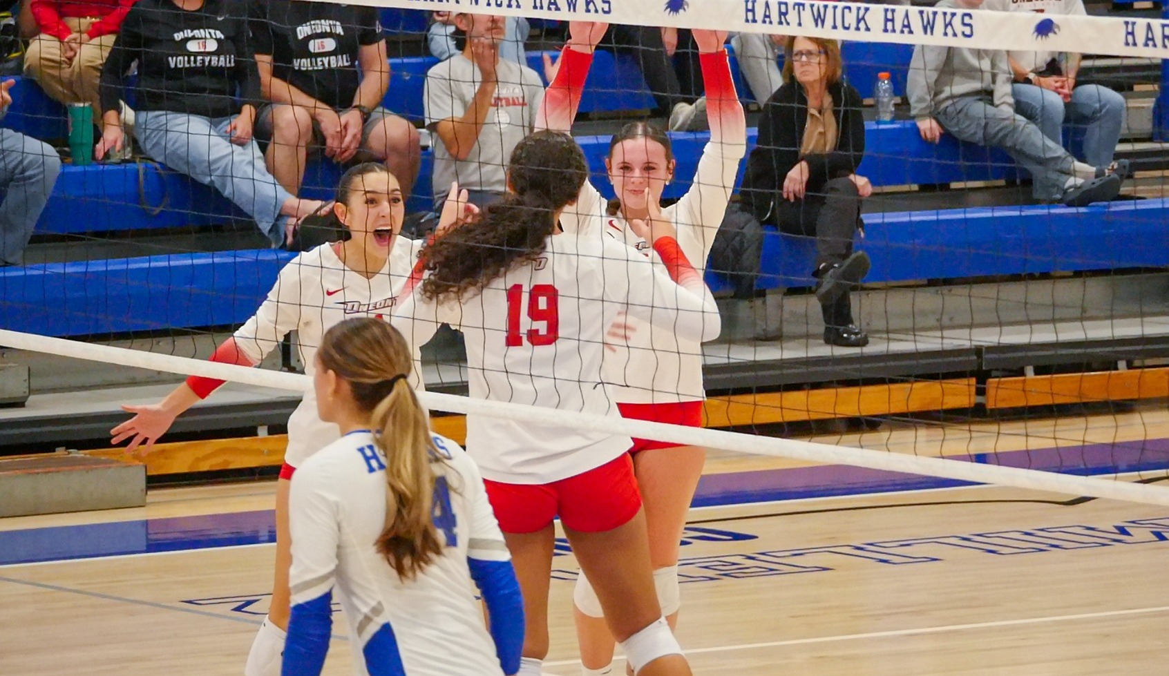 Emma Morretta, Corynna Manjos, and Layla Pertchik celebrate winning a point at Hartwick