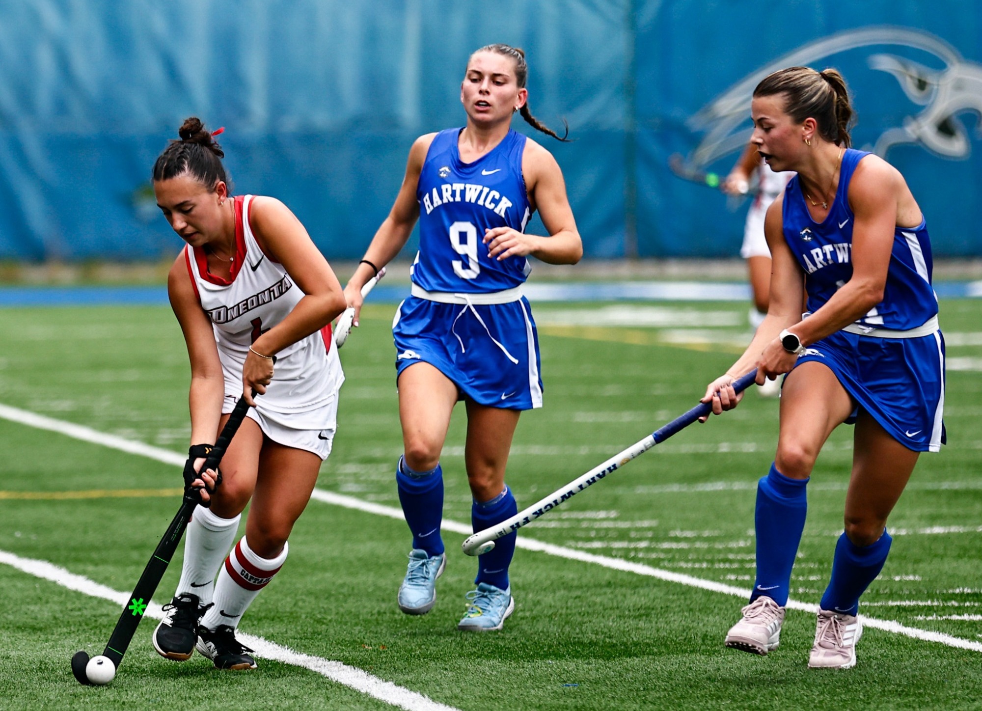 Marissa Stephan dribbles past a couple Hartwick defenders