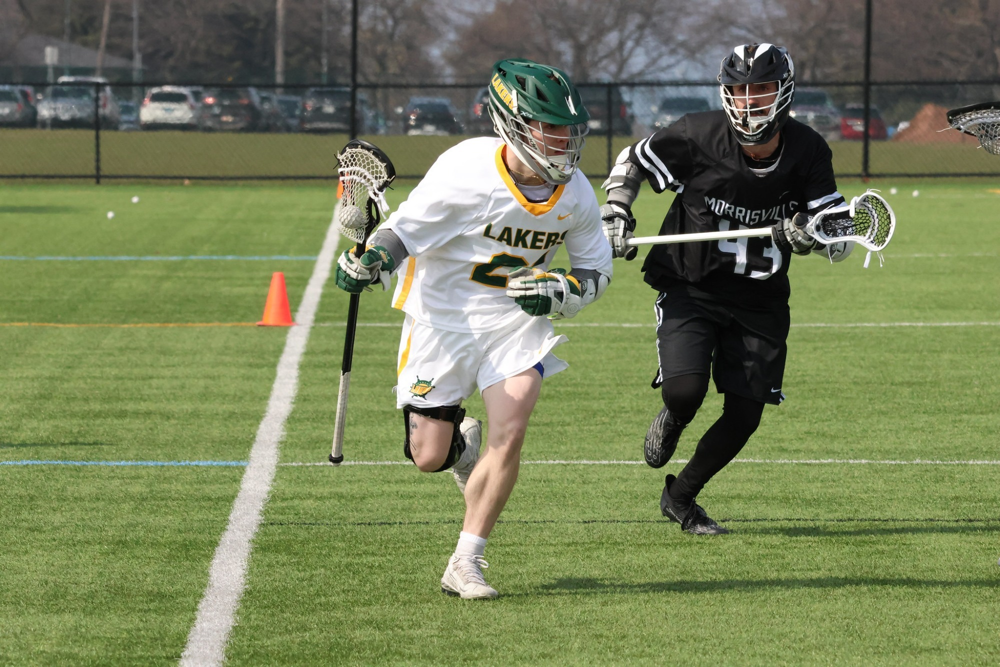 Lakers mens lacrosse player sprinting up field away from a defender