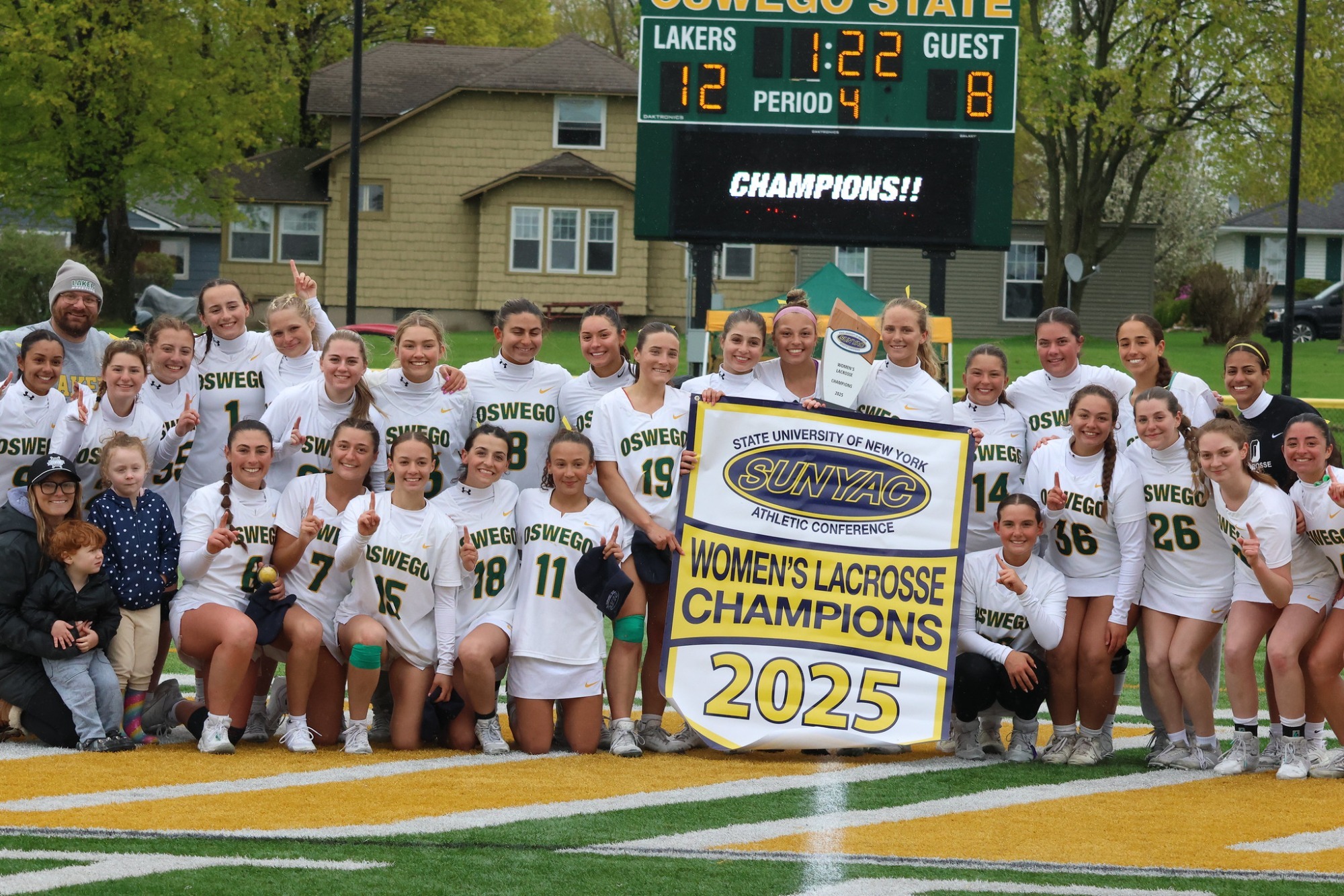 womens lacrosse team holding the 2025 SUNYAC championship banner