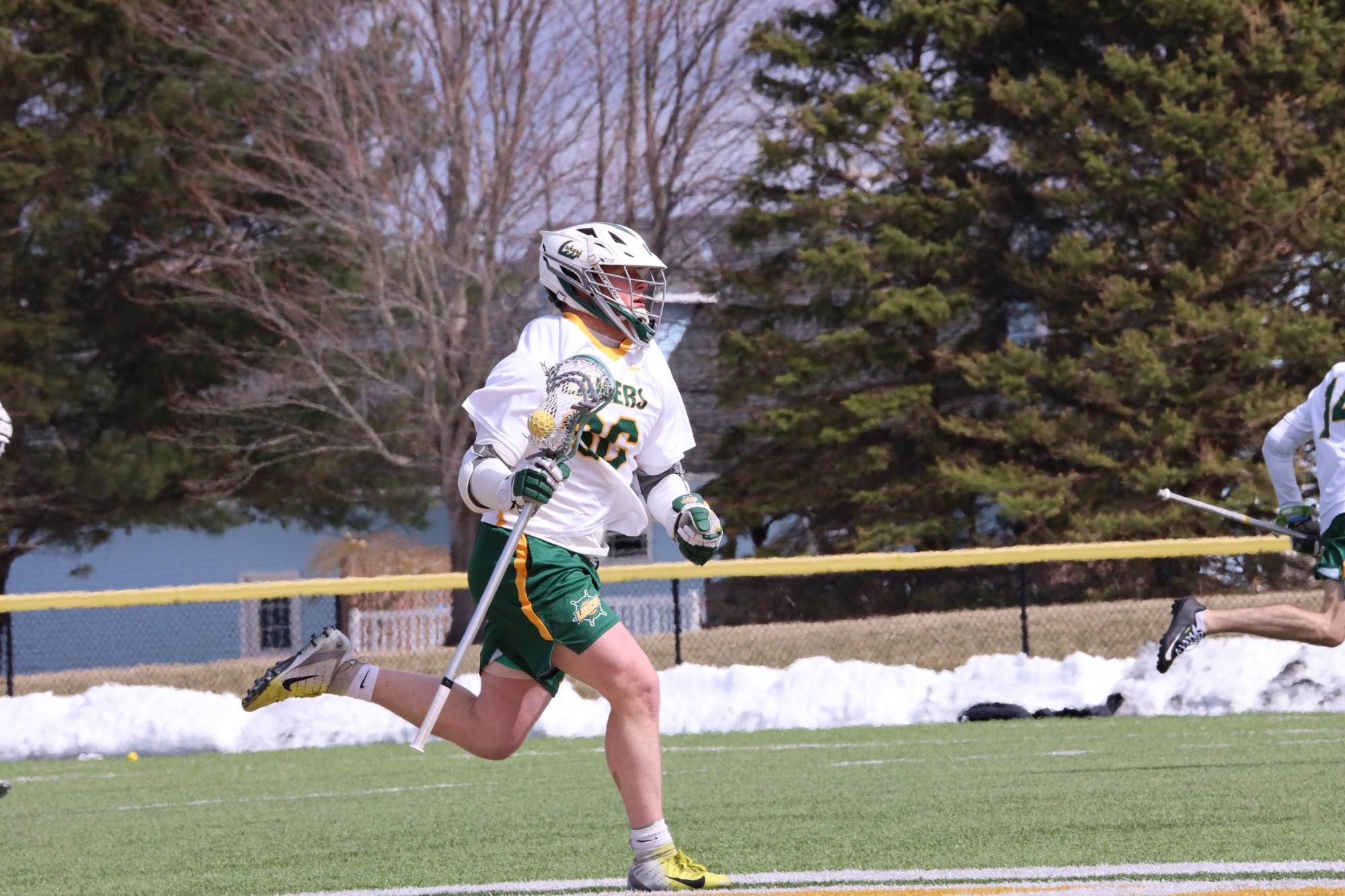 mens lacrosse player running up the field 