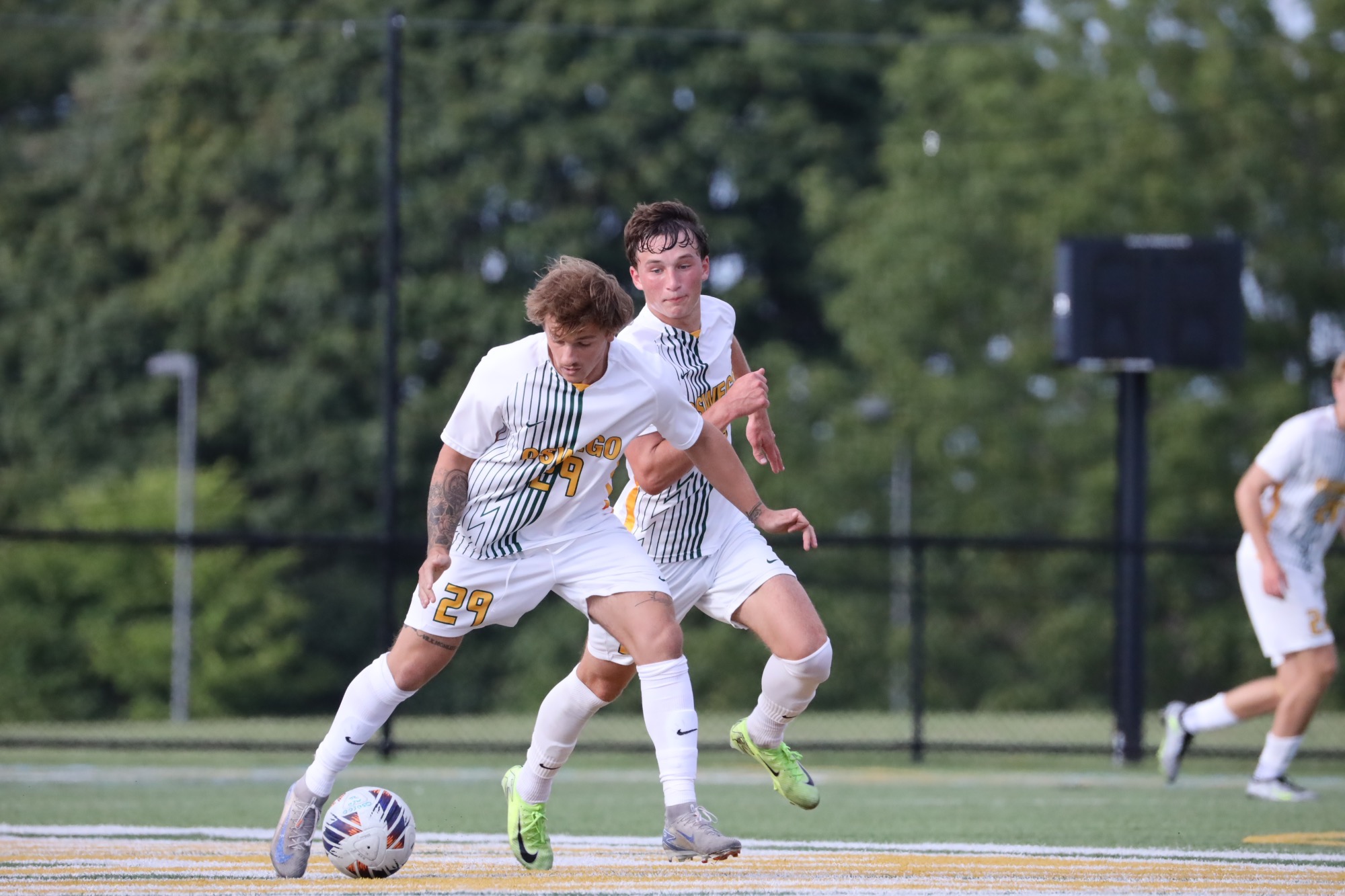 two players running side by side, carrying the ball up the pitch