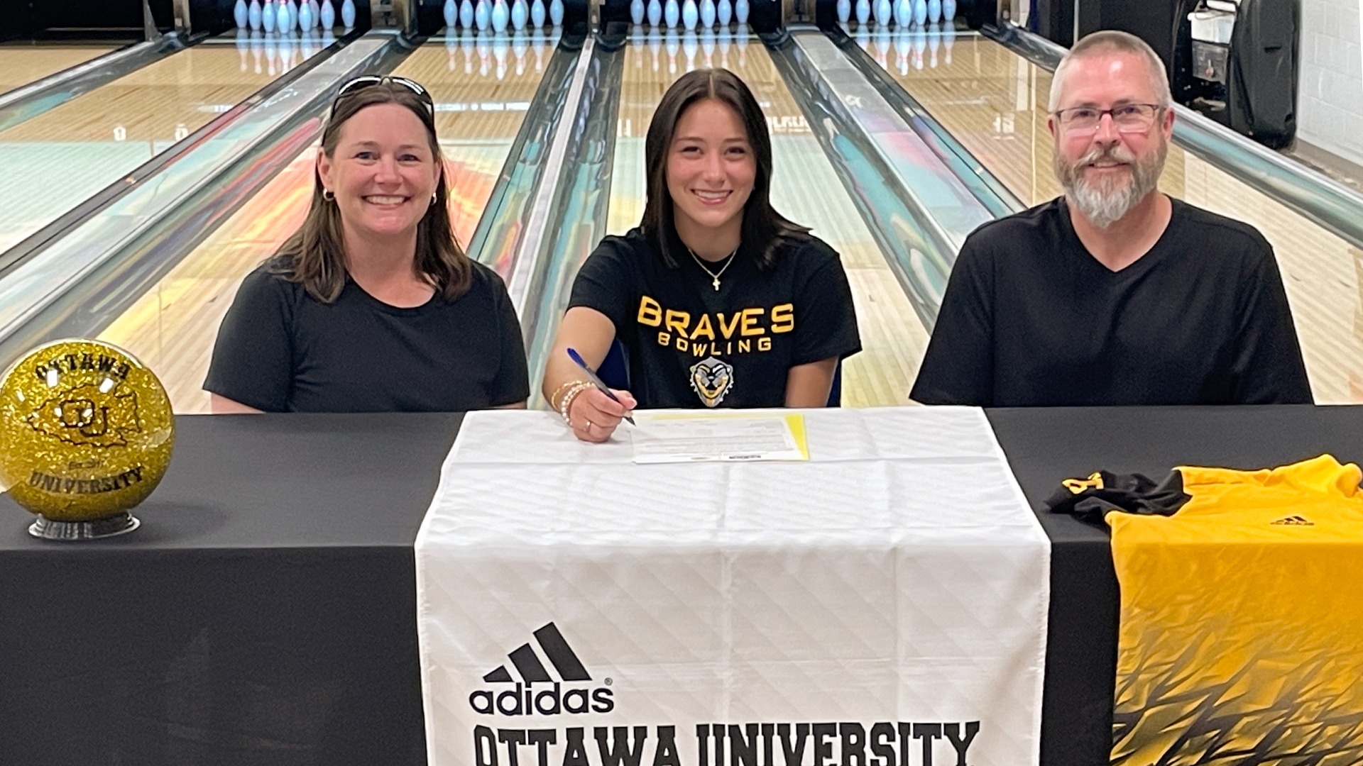 DeSoto HS senior Avery Lovegren (center) signs her letter of intent with Ottawa Women's Bowling. Also pictured are Lori (l) and Bryan Lovegren.