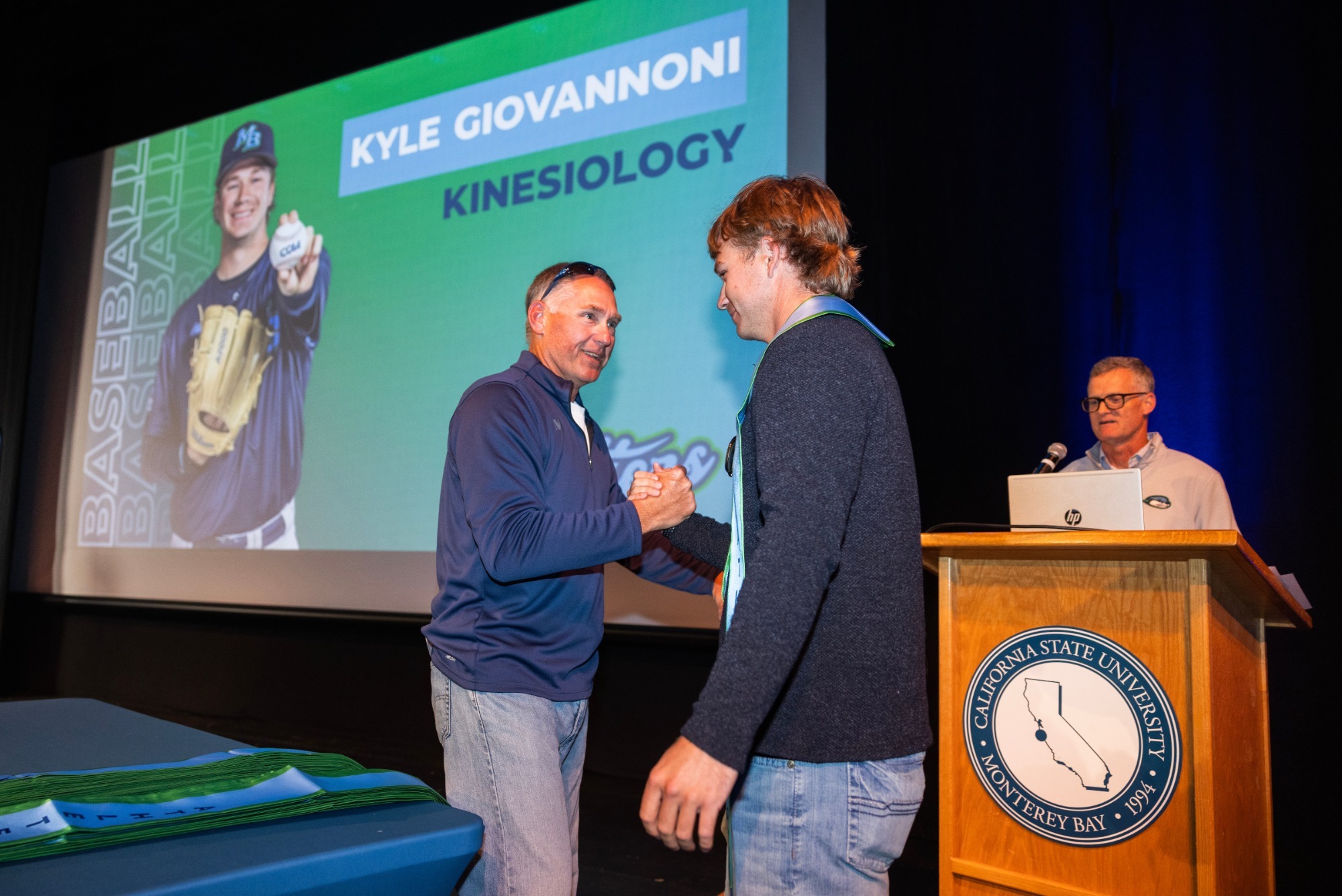 This is a photo of Walt White presenting a Otter Athletics graduation stole to Kyle Giovonnoni.