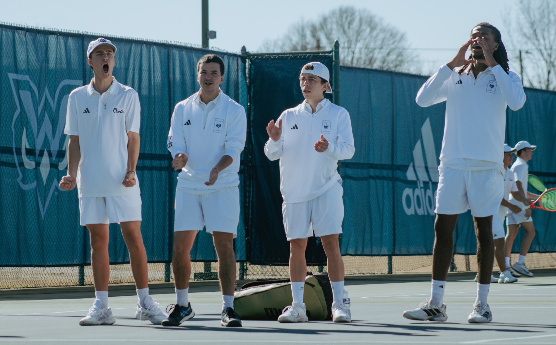 The W men's tennis cheers on a teammate