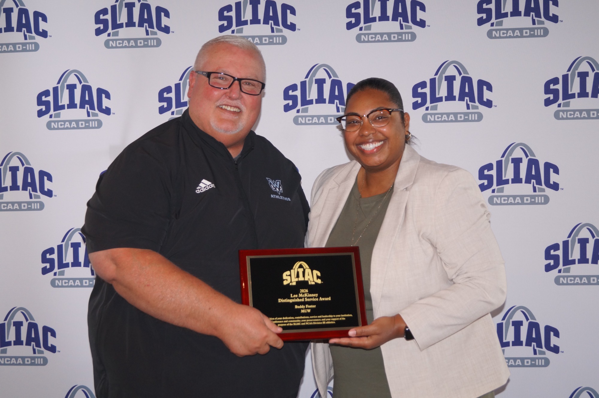 Buddy Foster (L), The W's Director of Athletics, receives the 2026 Dr. Lee McKinney Distinguished Service Award from SLIAC Commissioner Chassidy Holloway (R).