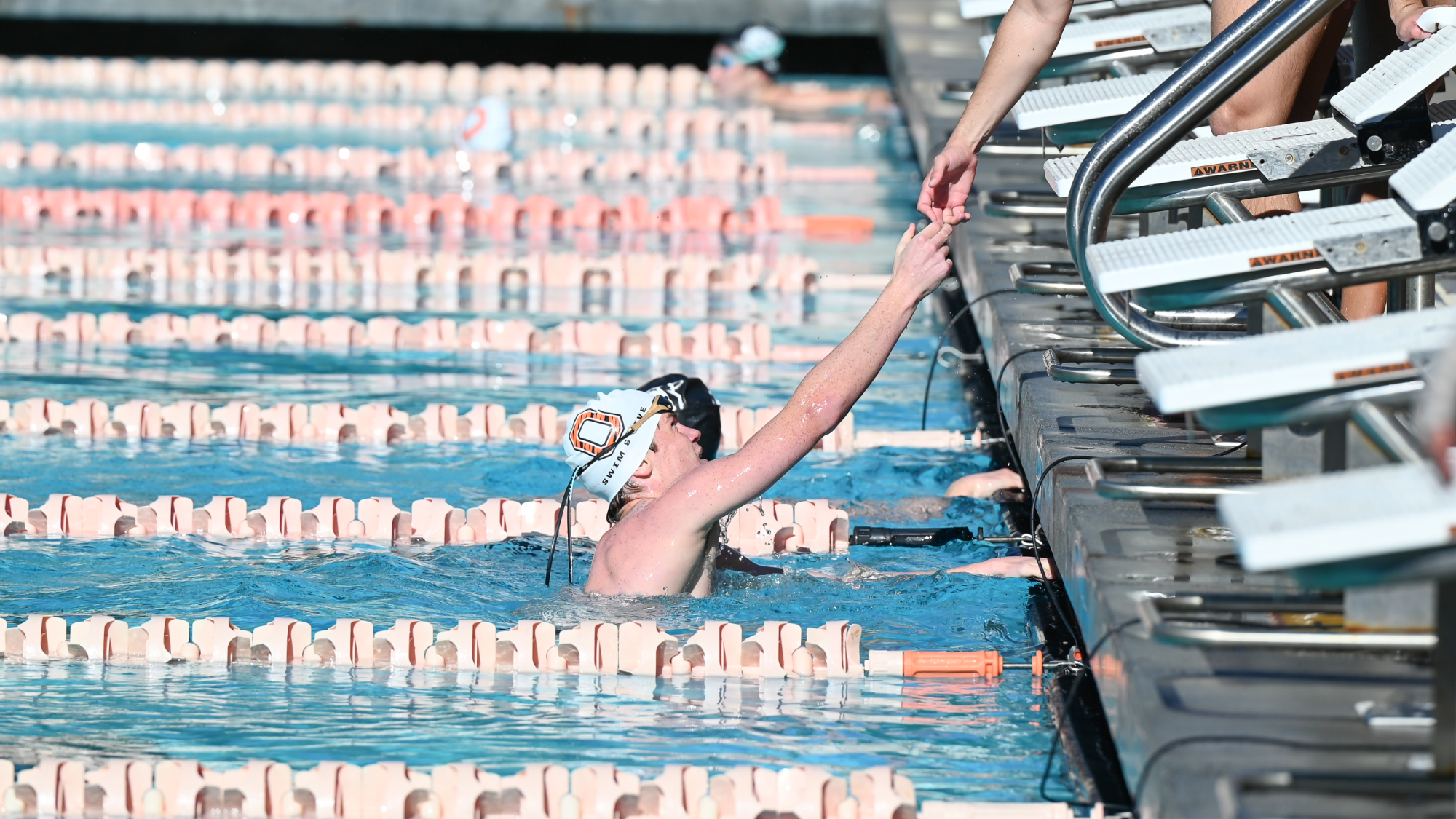 swimmer high fives teammate