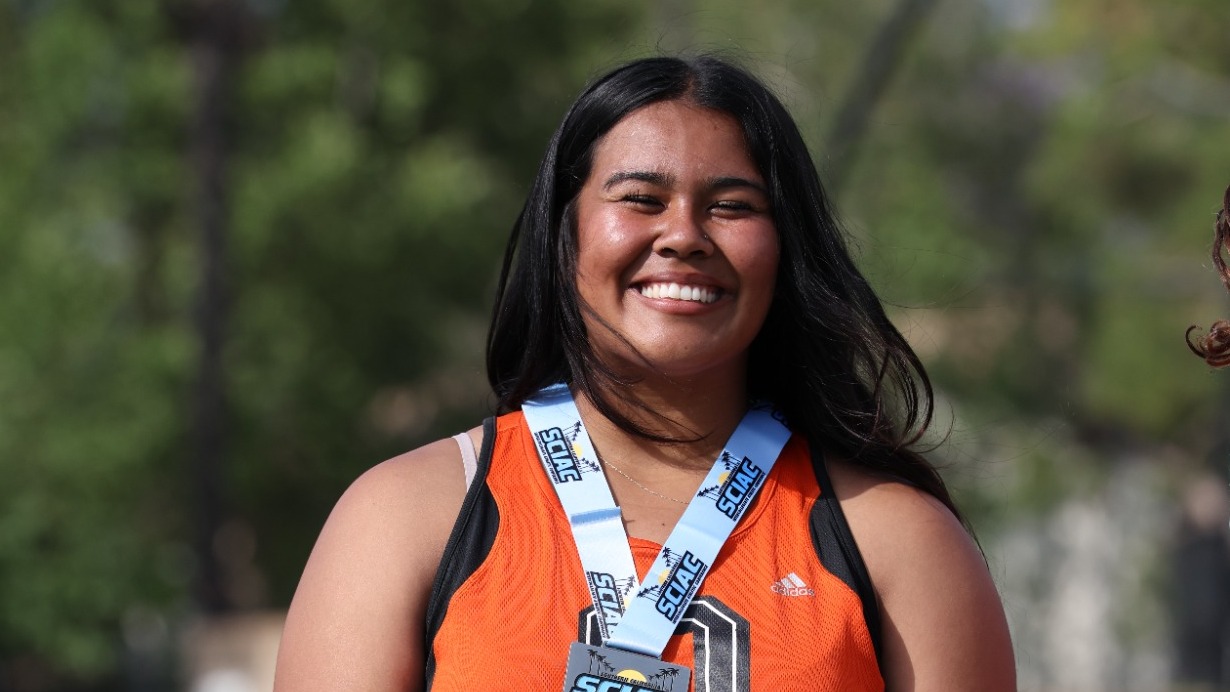 Kayla Sepulveda receives her medal as second-place finisher in the shot put at the SCIAC Championships