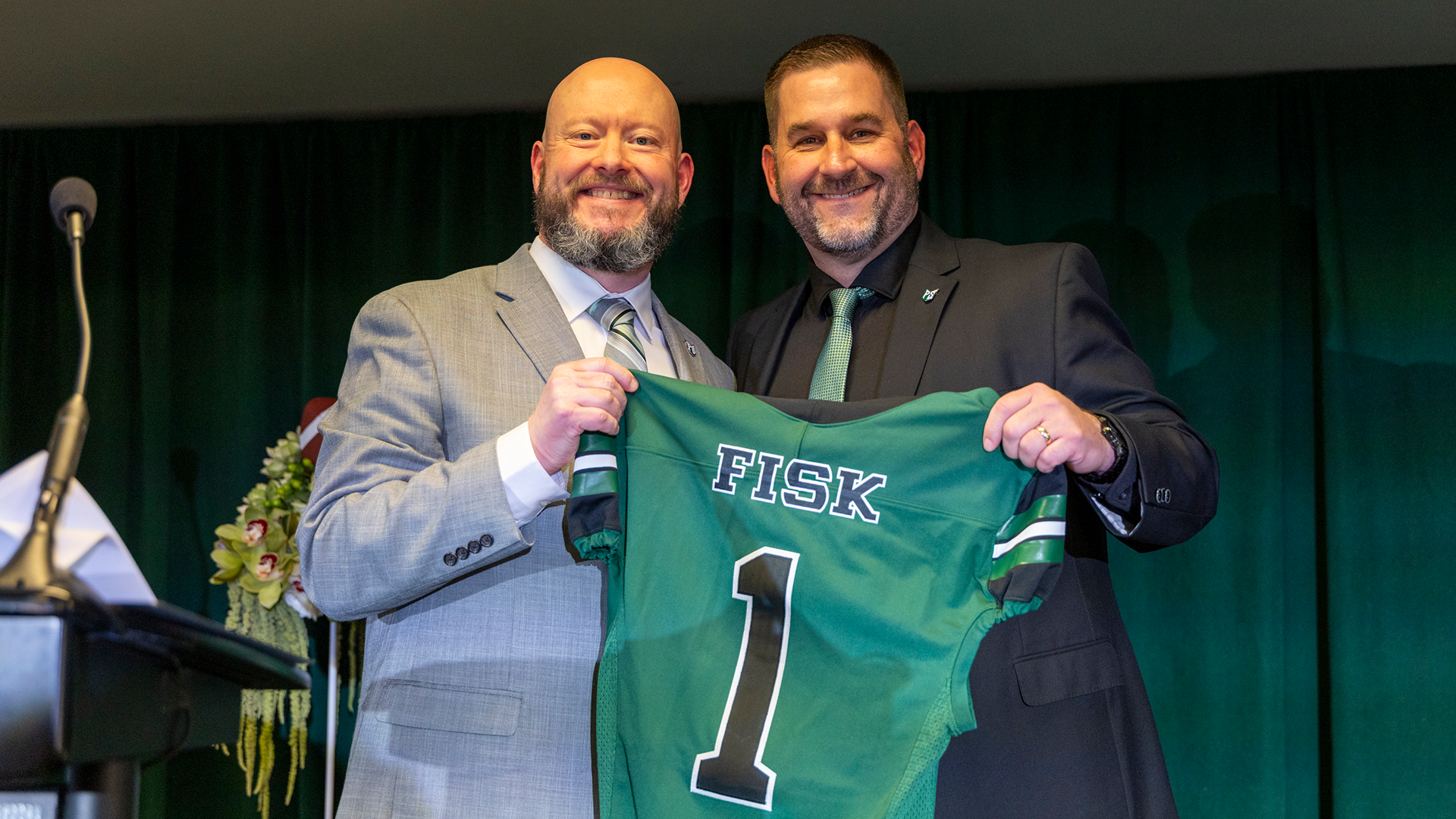 Portland State Athletic Director Matt Billings and Head Football Coach Chris Fisk hold up a jersey that says 