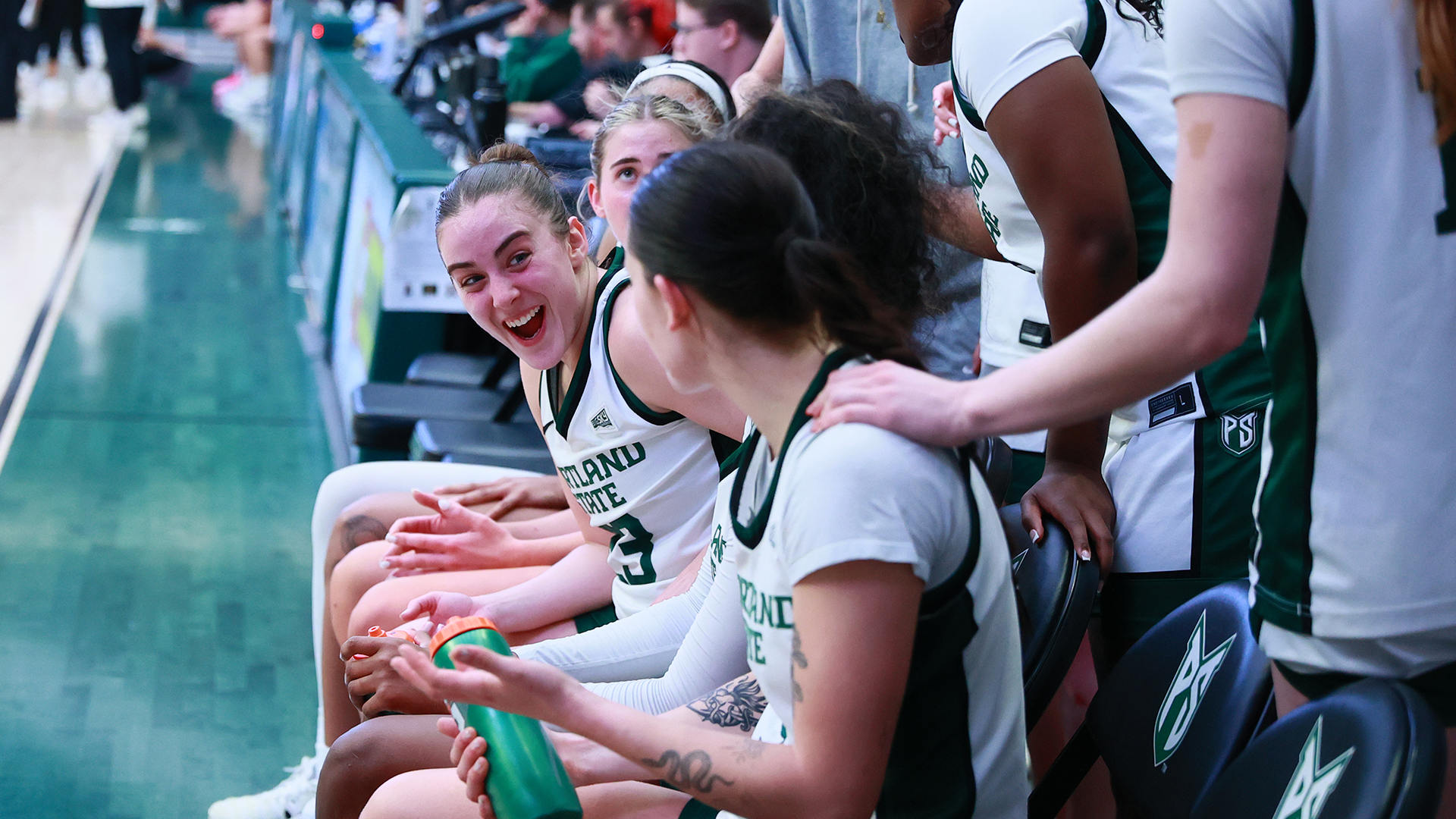 The Portland State women's basketball team smiles at each other on the bench during the Vikings' comeback victory over Weber State.
