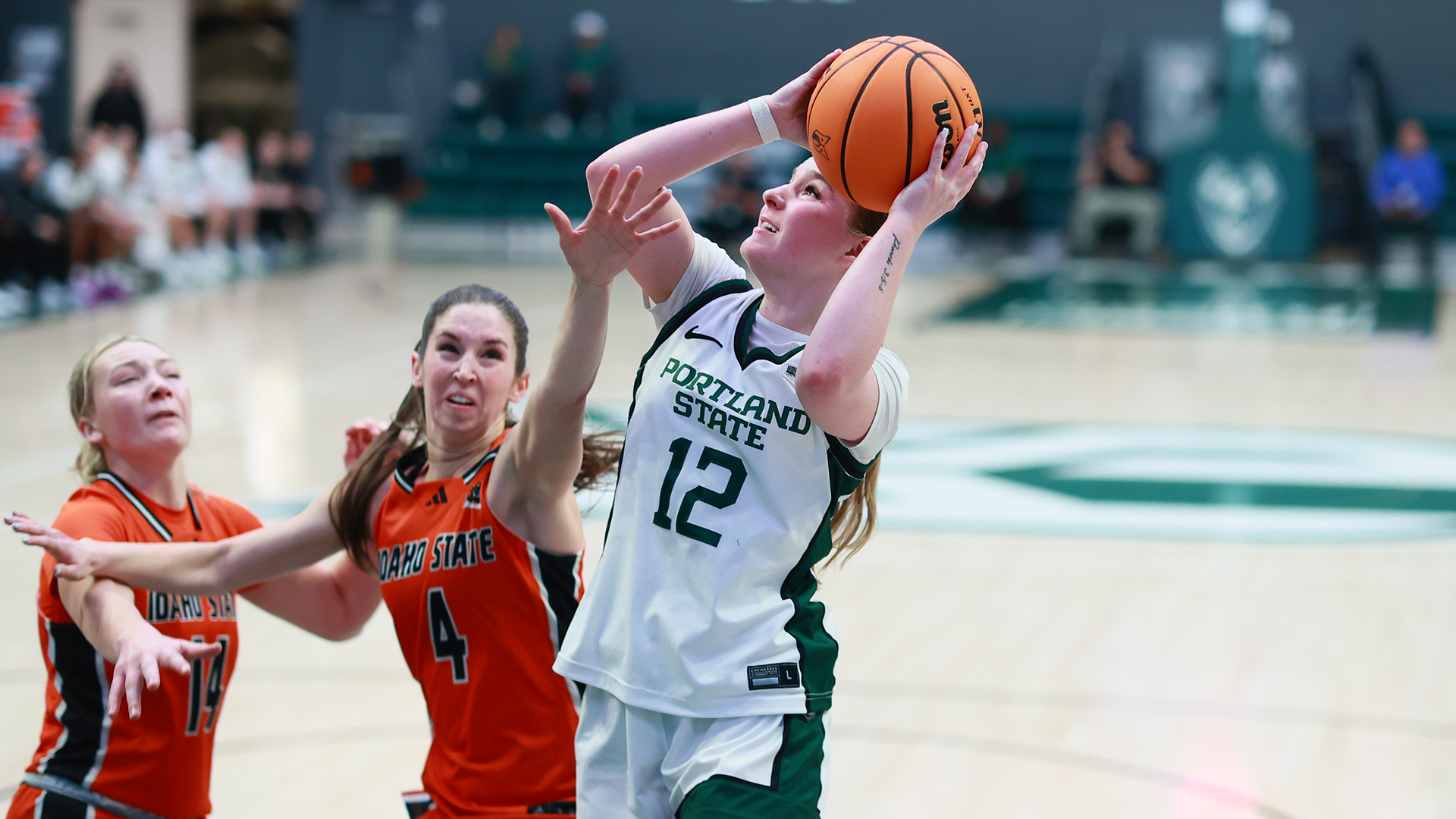 Portland State women's basketball player Kyleigh Brown goes up for a layup against two defenders in the Vikings' game against Idaho State.