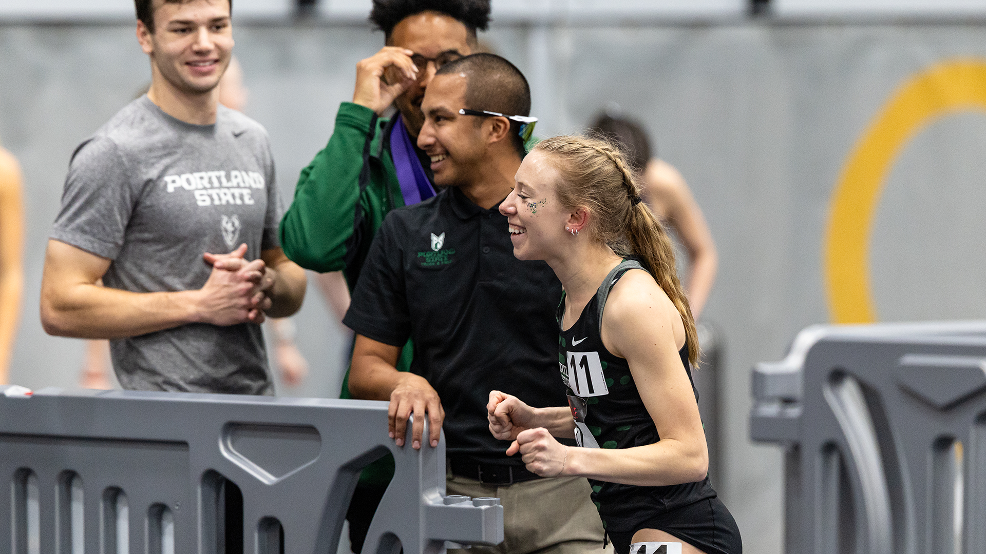 Portland State women's track & field runner Emma Stolte celebrates with coaches and teammates after setting the school record in the women's indoor 800 meters.