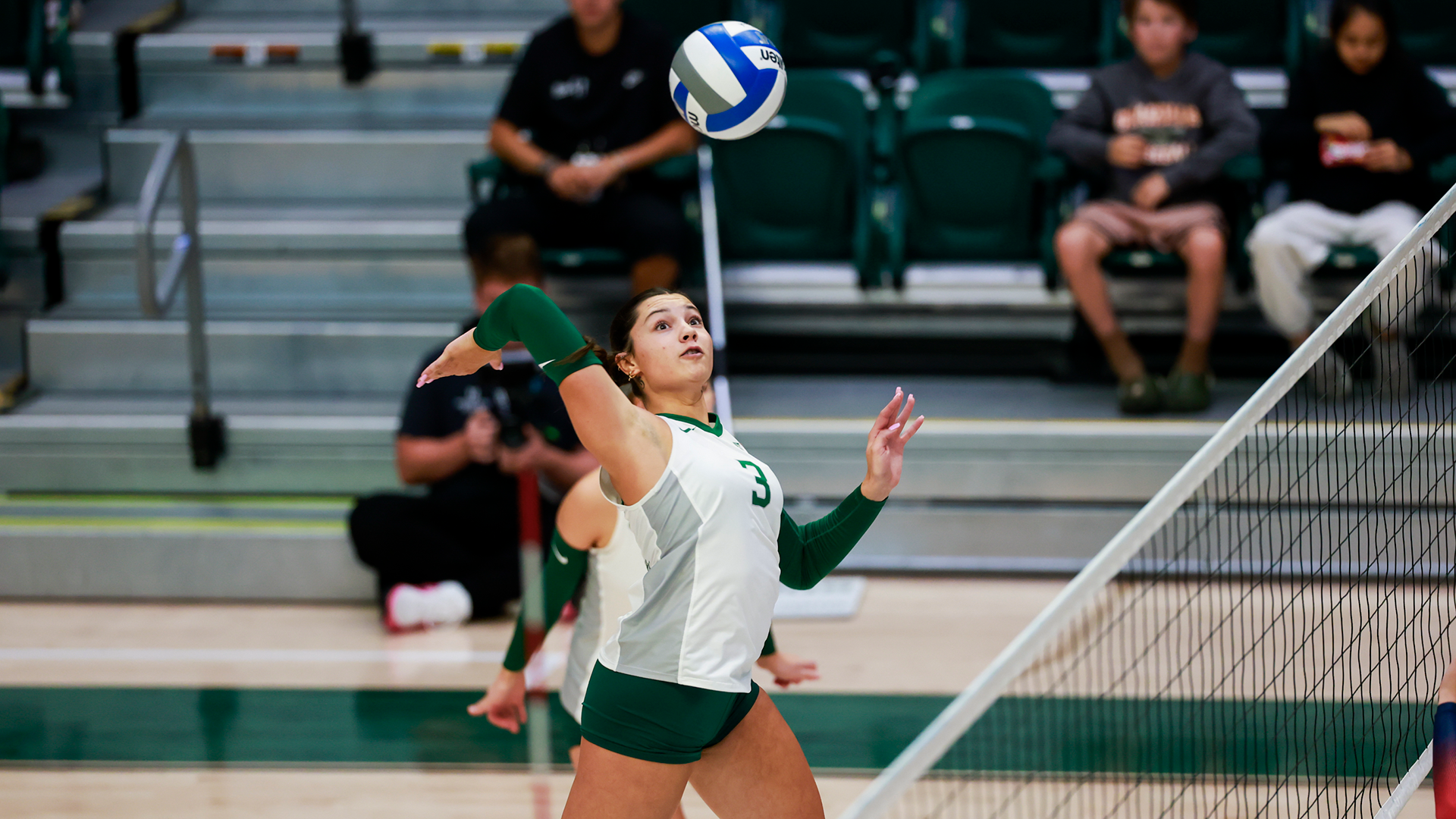 Portland State volleyball player Brenna Coffman hits a ball over the net during a match.