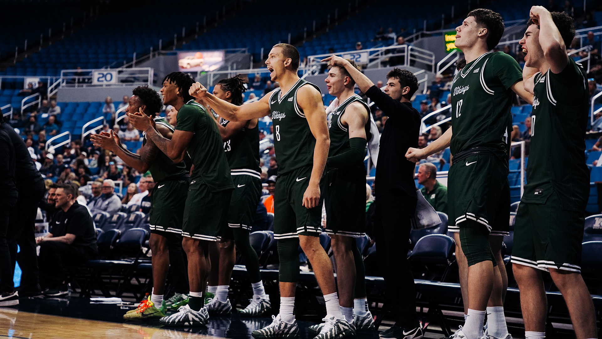 The Portland State men's basketball team's bench celebrates a made basket during the Vikings' exhibition against Nevada.