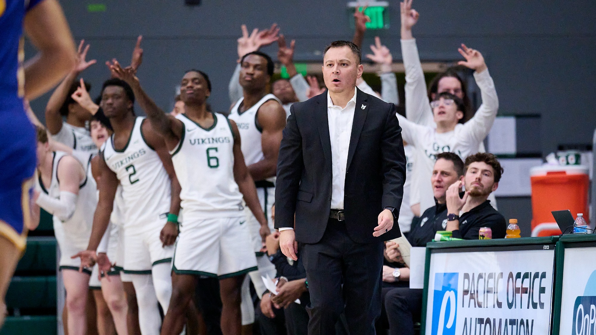 Head Coach Jase Coburn with his team celebrating a three-point field goal