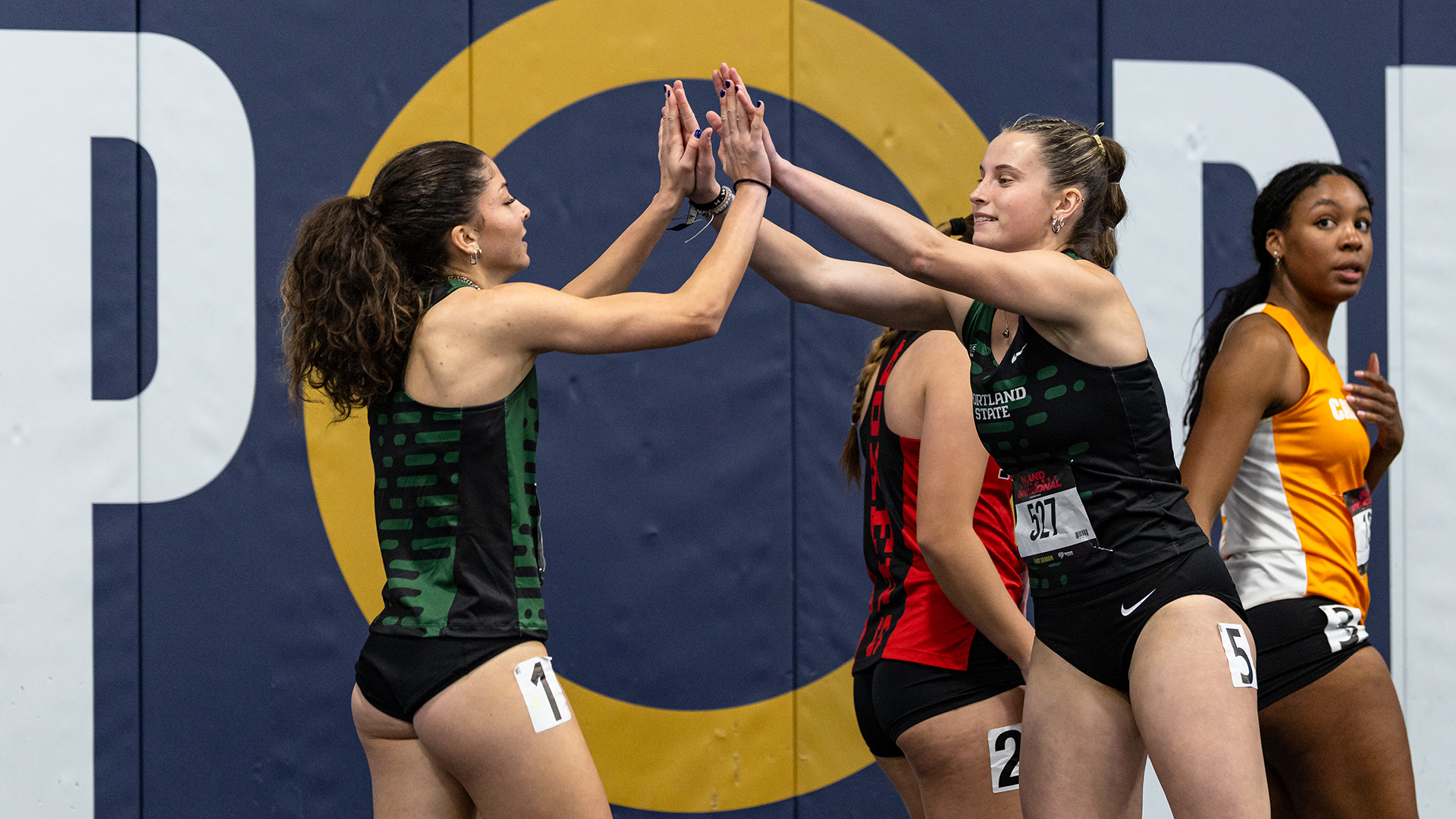 Portland State track & field athletes Ashley Peterson and Ocean Rideout high five after a race at the Inland Northwest Invitational