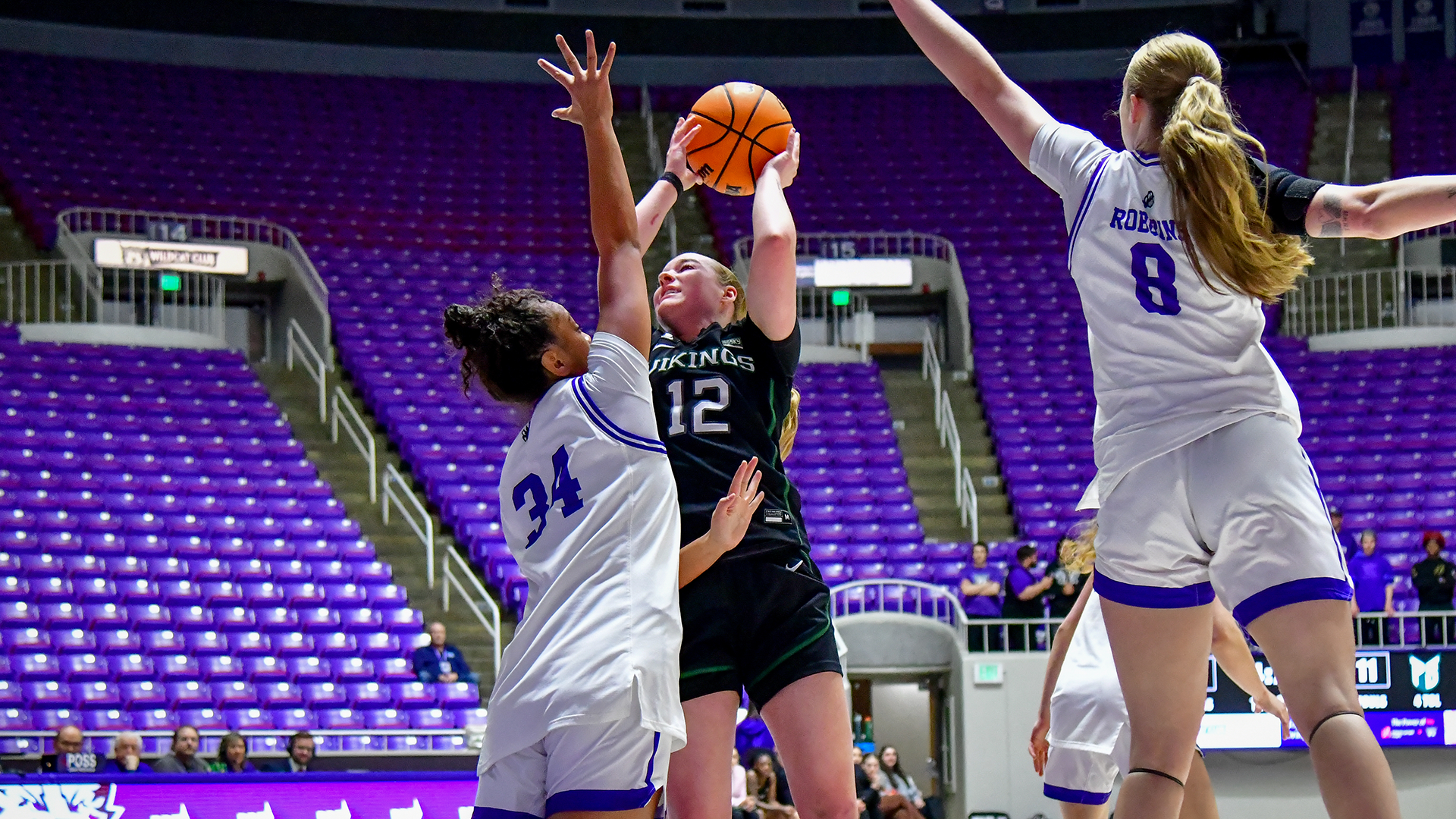 Portland State women's basketball player Kyleigh Brown goes up for a shot against two Weber State defenders.