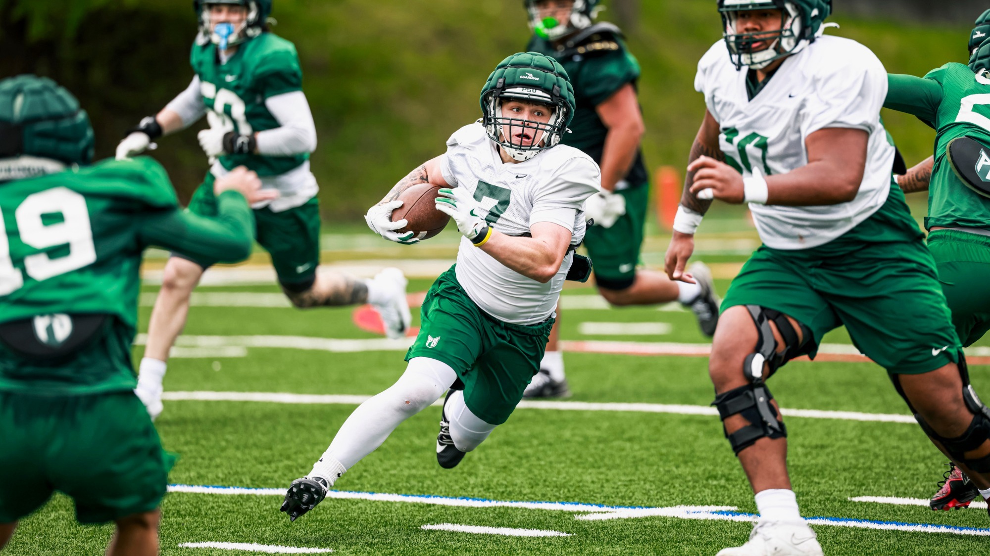 Offensive lineman Kapeliele Hausia (60) looks for a block while transfer running back Niall Raby (7) hits the hole.