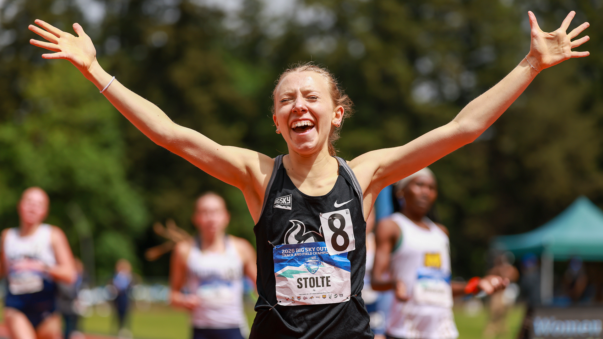 Portland State track & field athlete Emma Stolte raises her arms in triumph after placing second in the 1,500 meters at the Big Sky Outdoor Championships