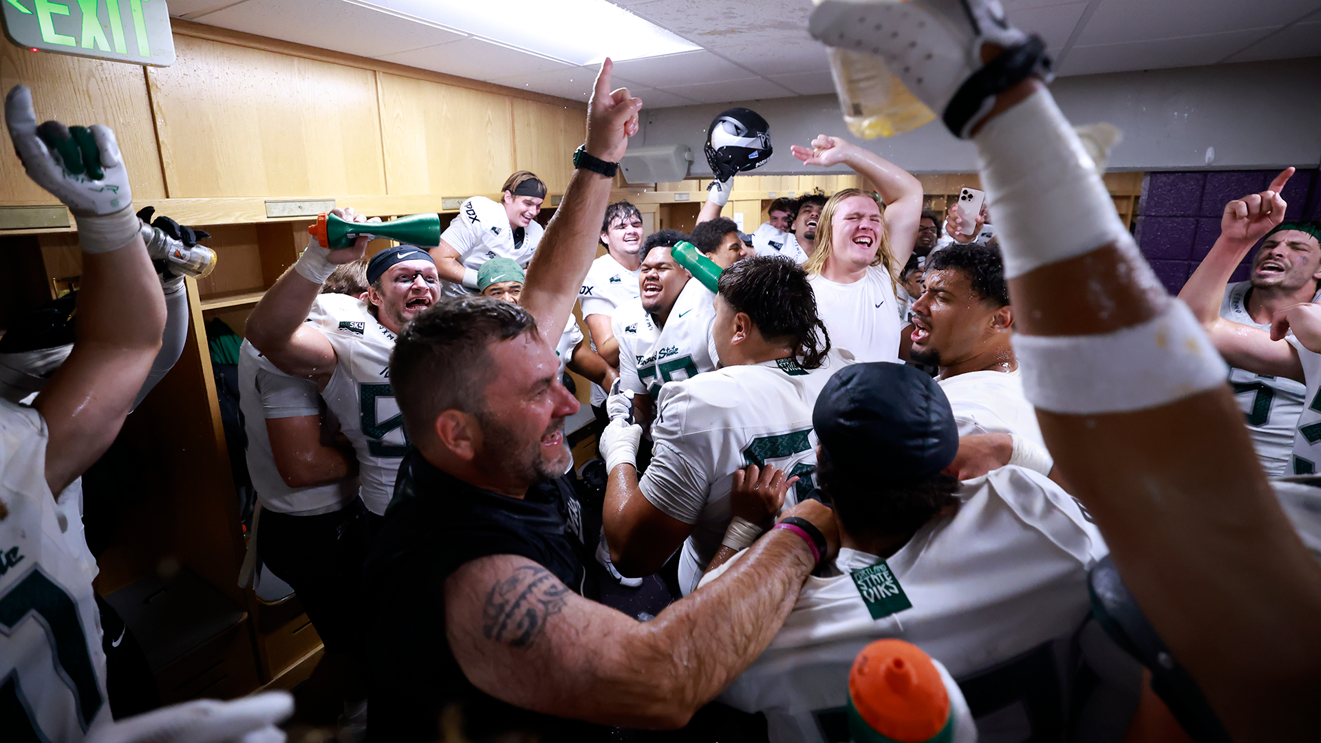The Portland State football team celebrates its first win under head coach Chris Fisk in the locker room at Weber State.