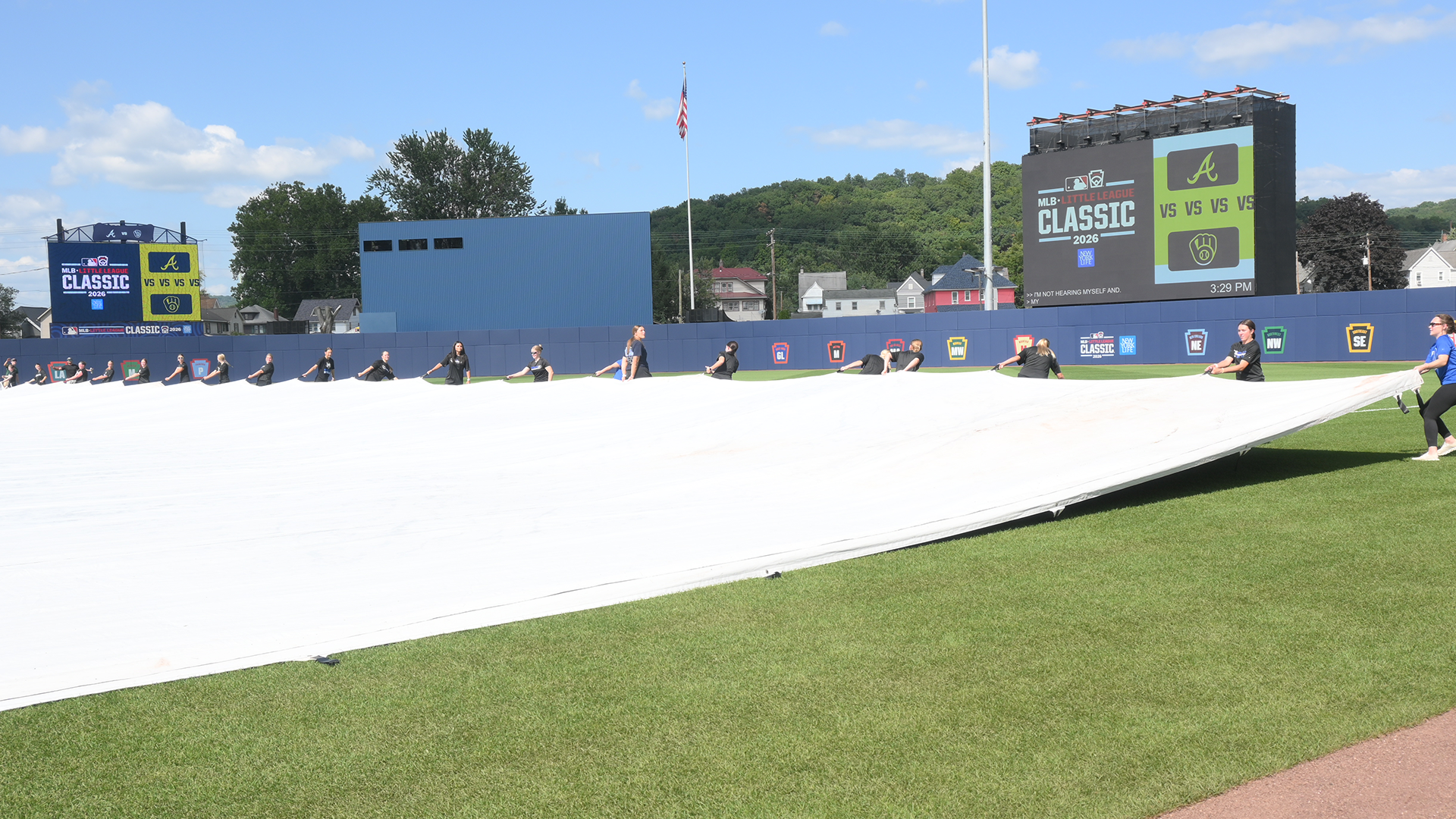 Members of the Penn College Softball team practice deploying the tarp on the baseball field ahead of the 2026 MLB Little League Classic game