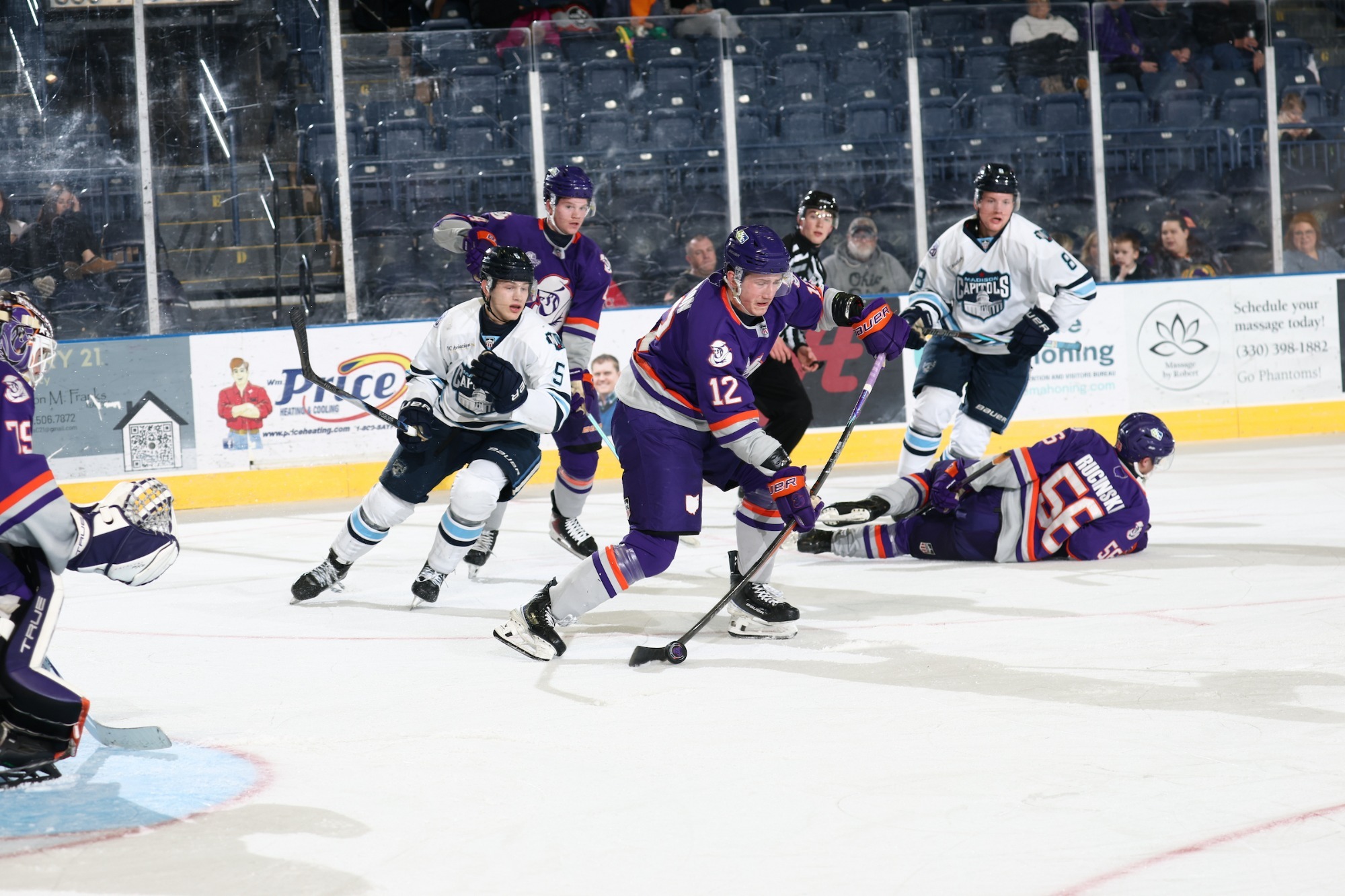 CAL HUSTON BATTLES FOR A PUCK AGAINST THE MADISON CAPITOLS