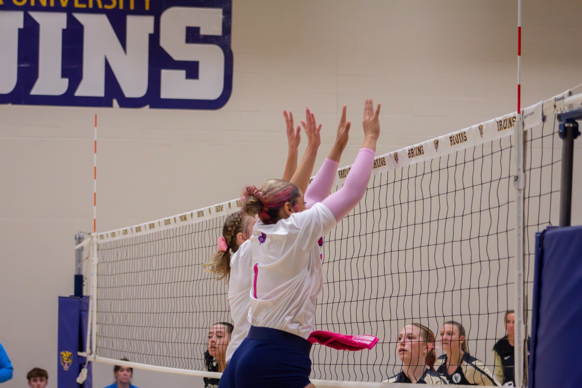Teammates going up for a block