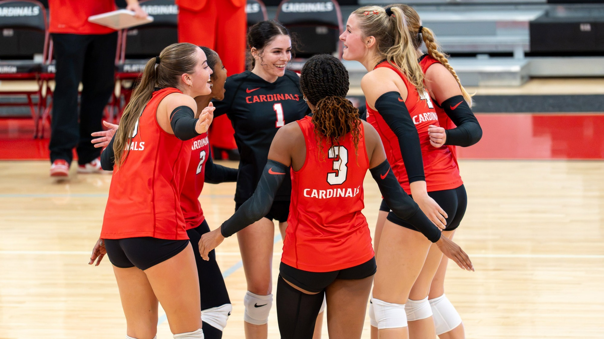 Women's Volleyball huddle on court