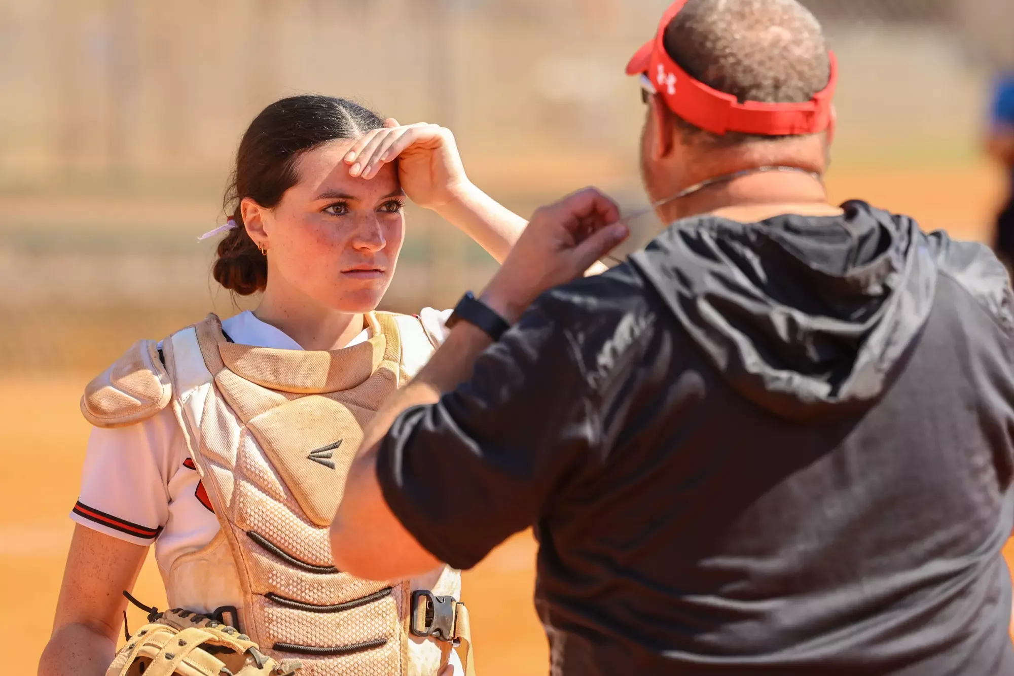 Coach Lewis has a conversation with his catcher, Leia Hurst