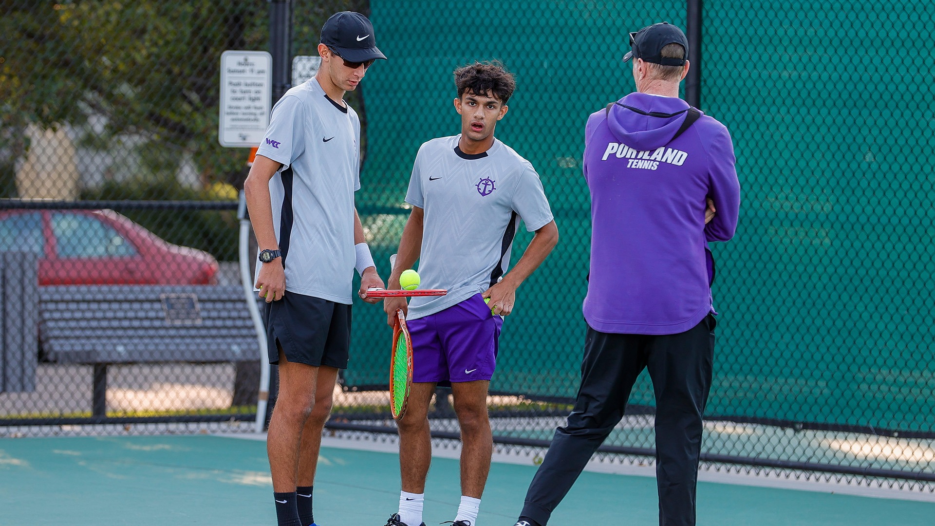 Eli Noel and Gian Manhas talk between doubles points with coach Aaron Gross.