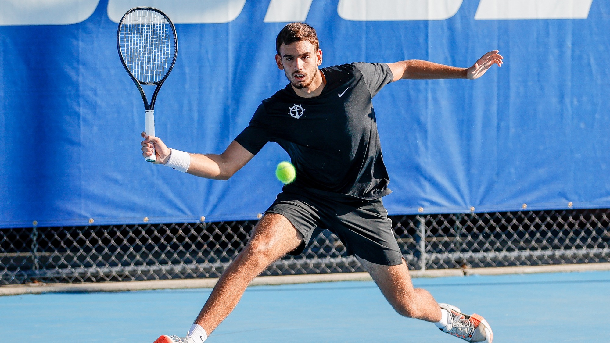 Stefan Skobelev hits a slice forehand in a fall singles match.