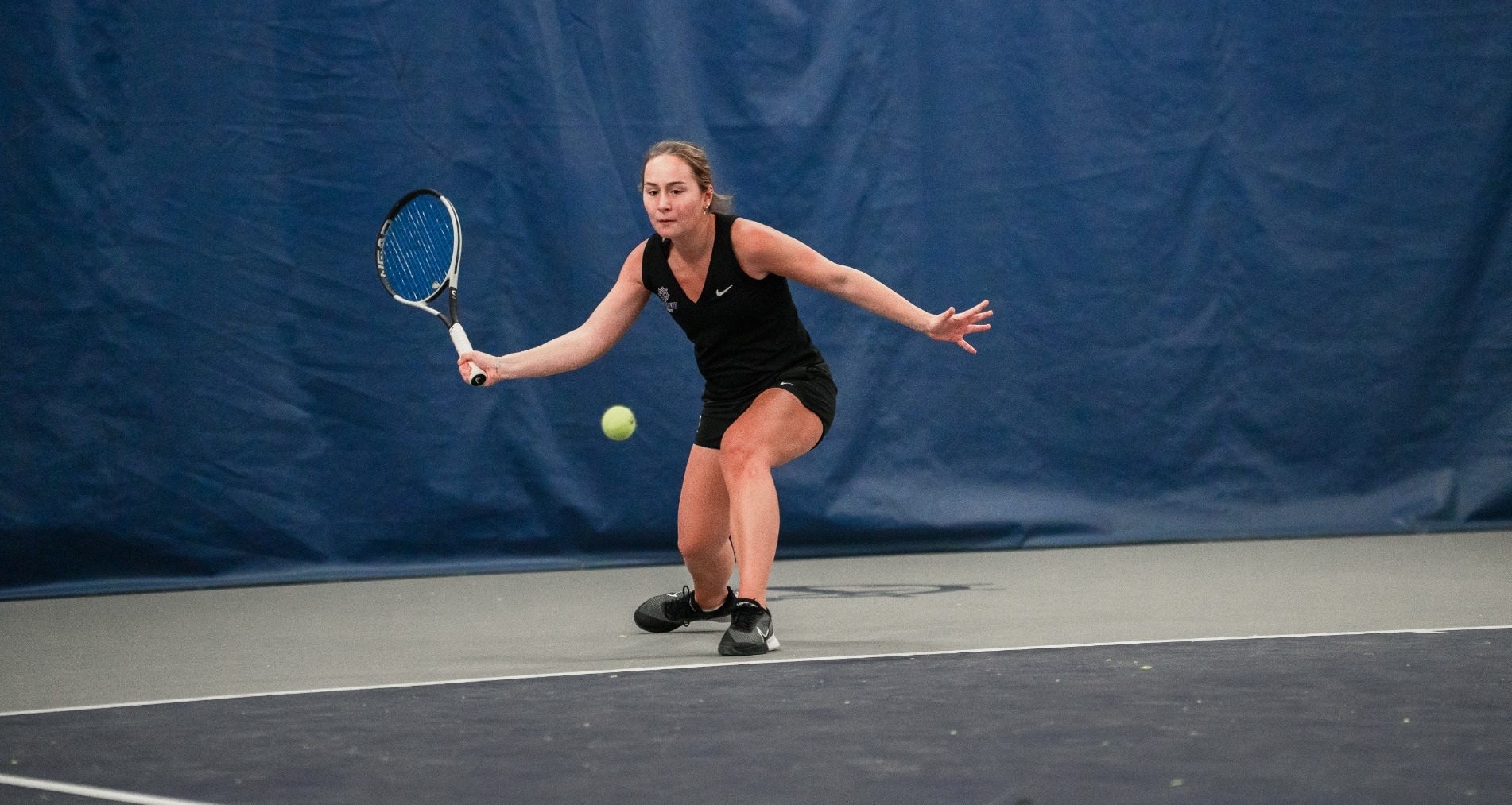 Maria Galatescu hits a forehand in a match.
