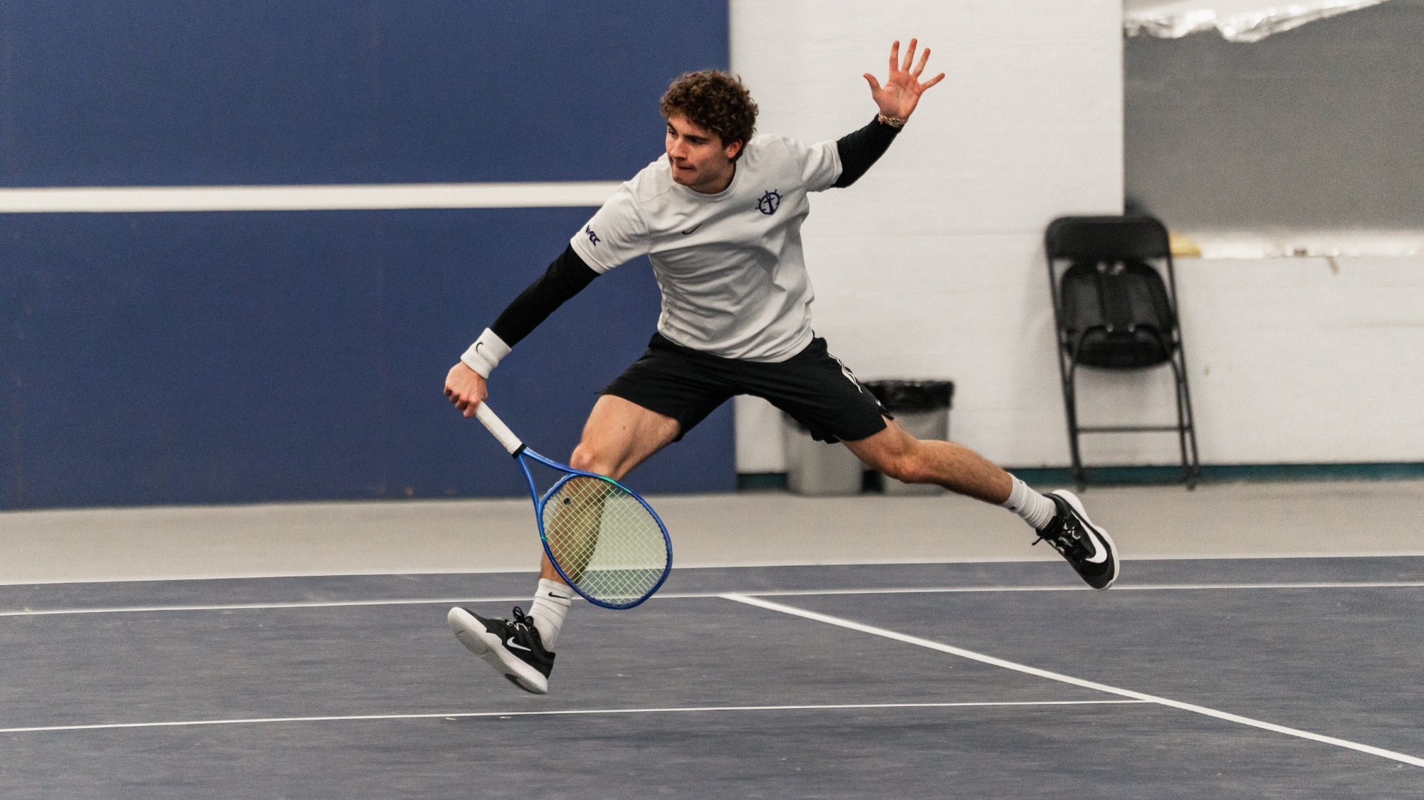 Tom Garcia stretches for a volley at the net against Portland State.