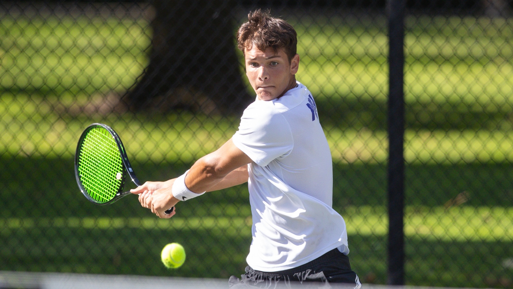 Cade Fernando hits a backhand during a singles match.