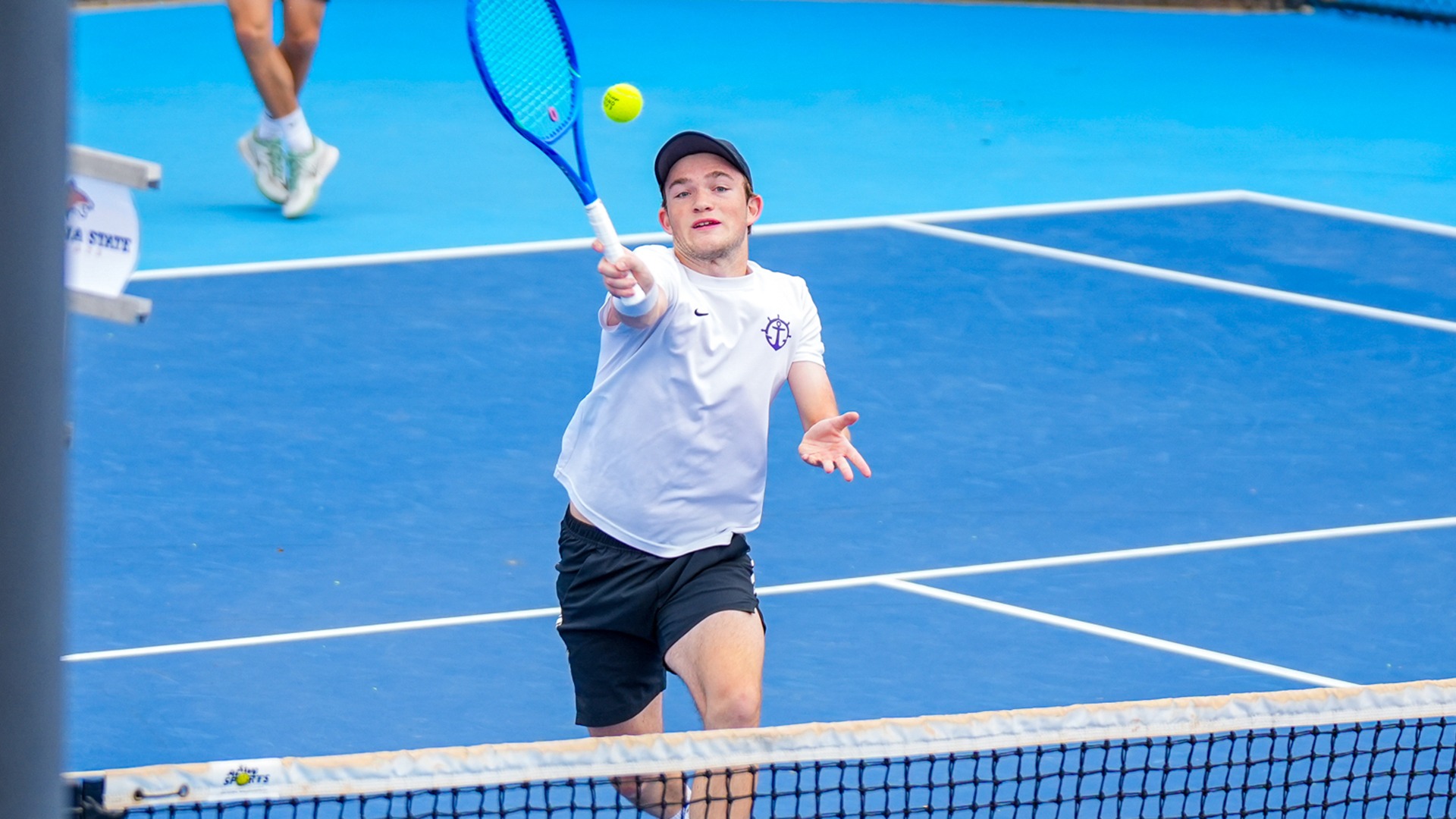 Tannor Binder hits a volley at the net during a fall doubles match.