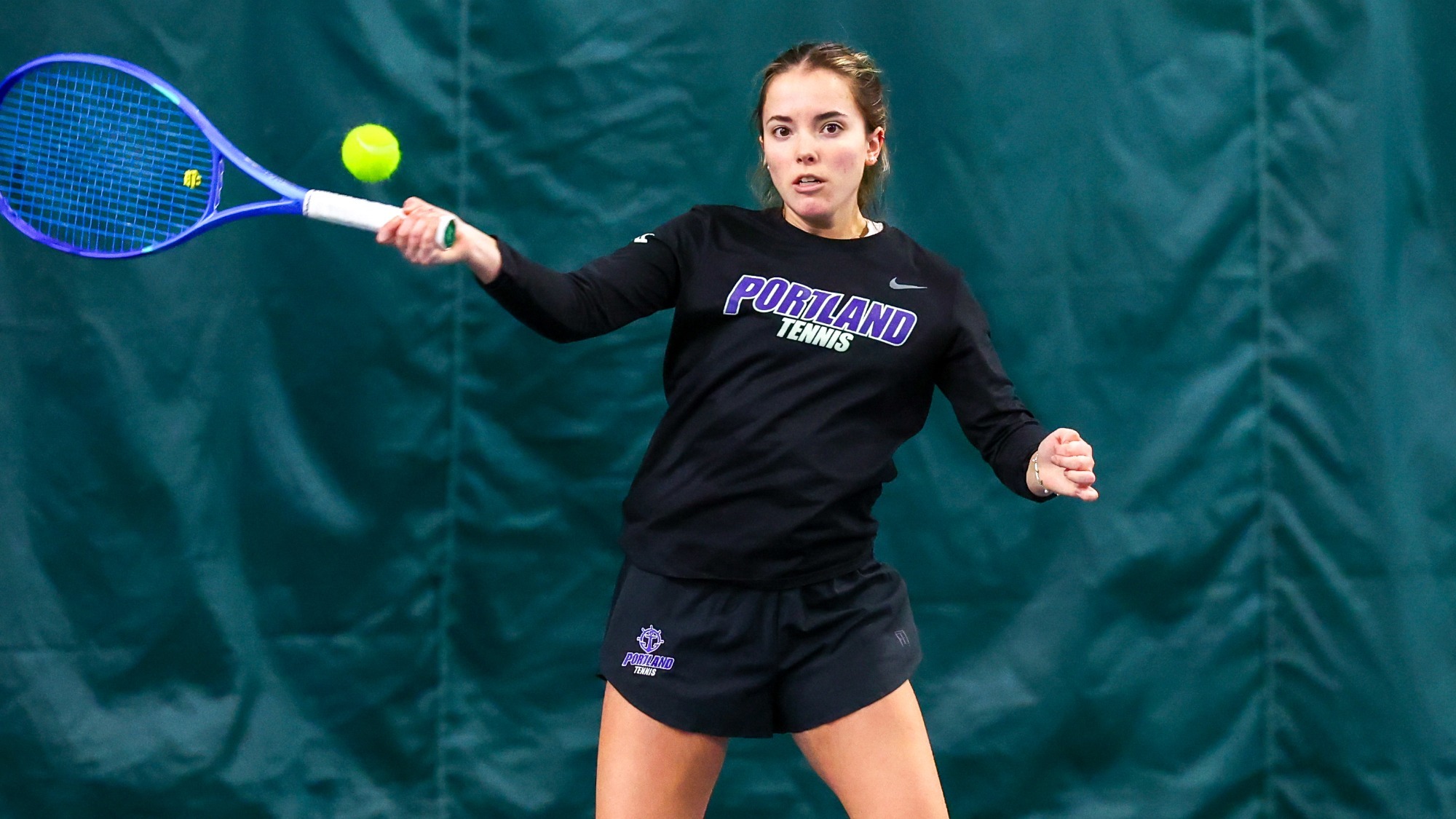 Nadine Arbaizar Martinez hits a forehand at the net during a singles match.