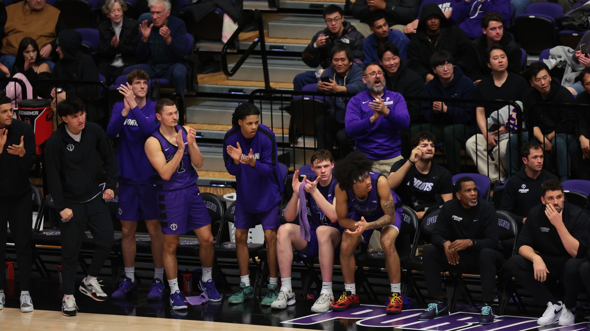 Portland men's basketball's bench celebrates during a home game versus Seattle U.
