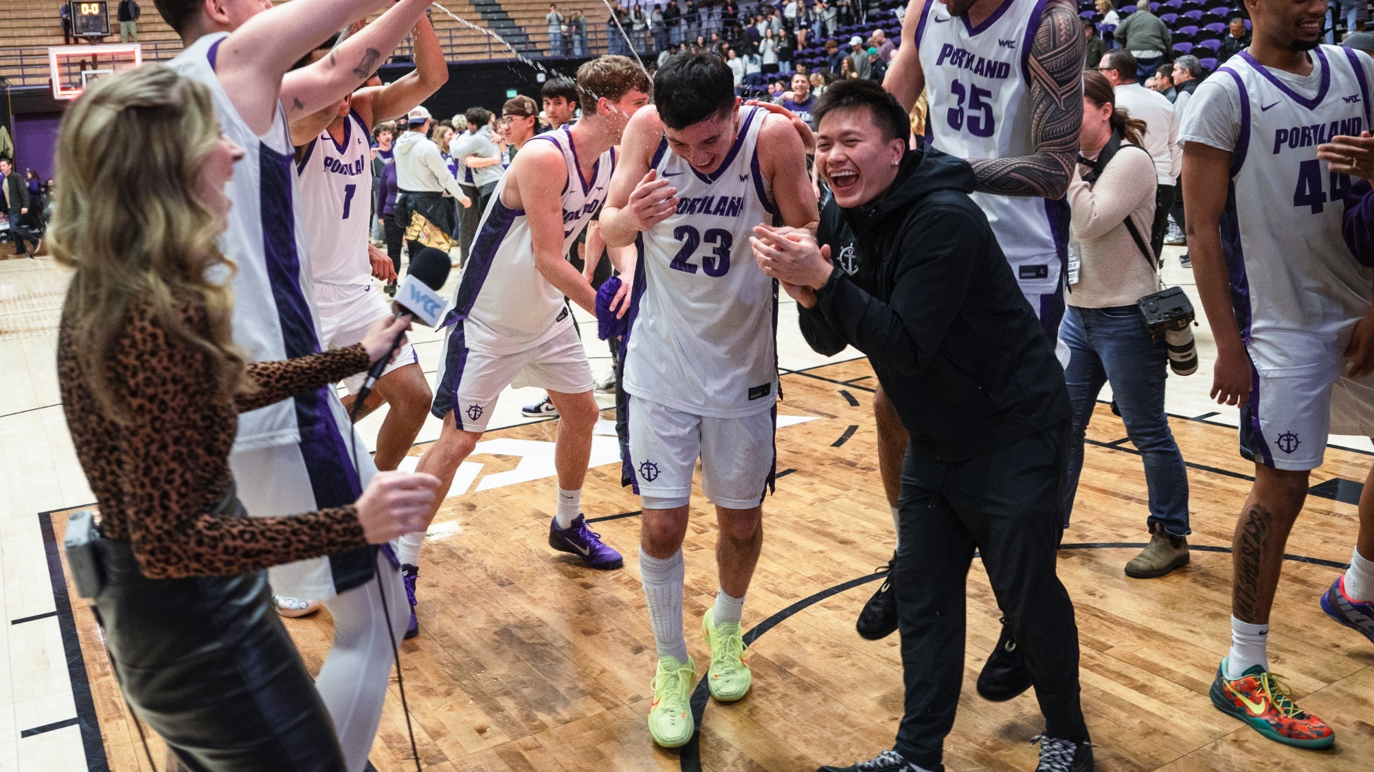 Joel Foxwell celebrates with teammates on the court after defeating No. 6 Gonzaga.