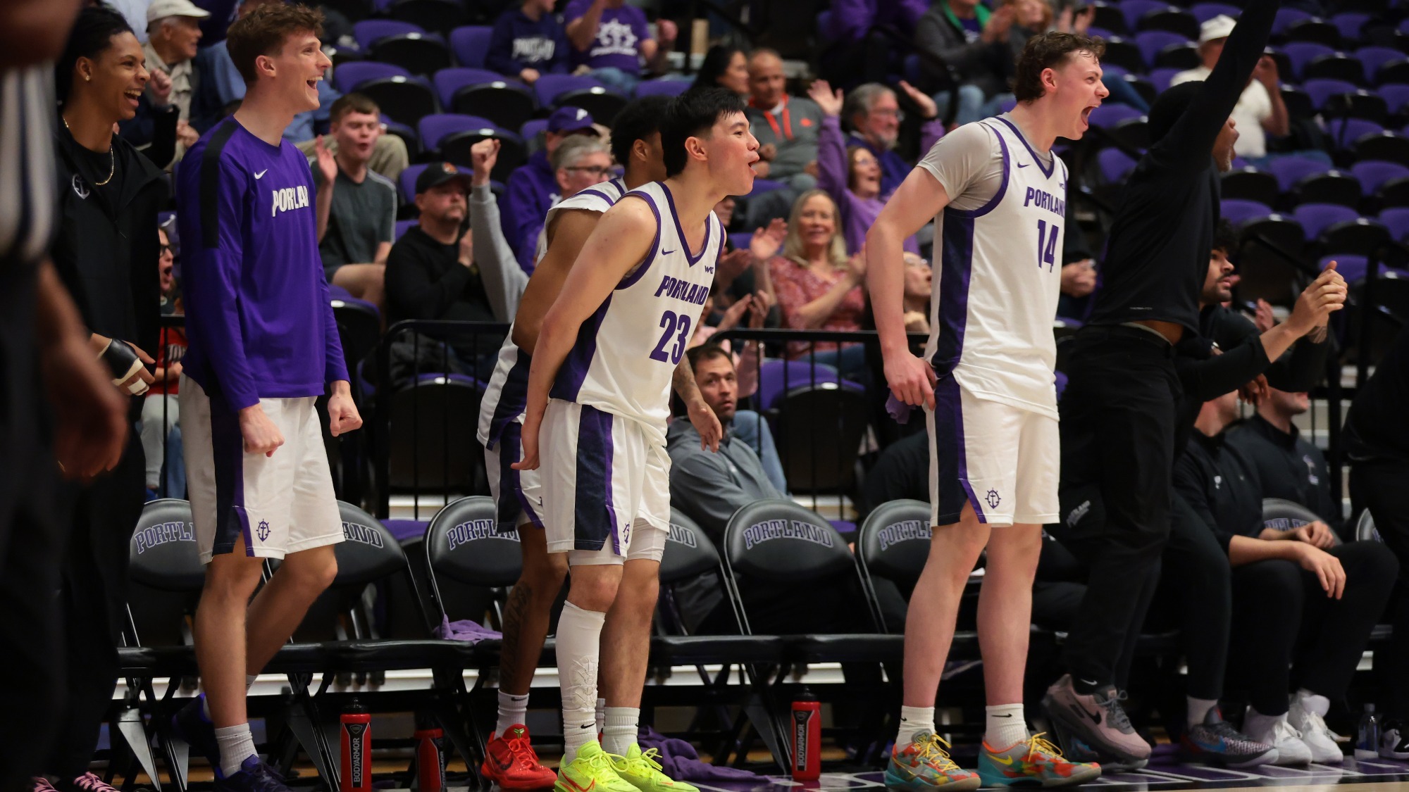 Portland men's basketball's bench celebrates late in a home win against San Diego.