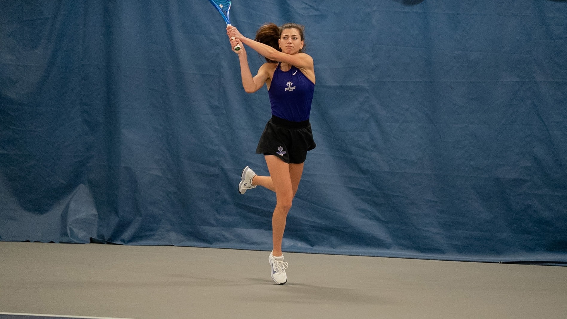 Dariya Radulova hits a backhand during a home singles match.