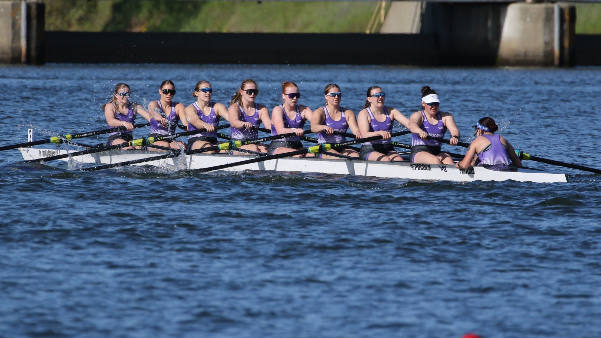 Portland's varsity 8 rowing team on the water in a regatta.