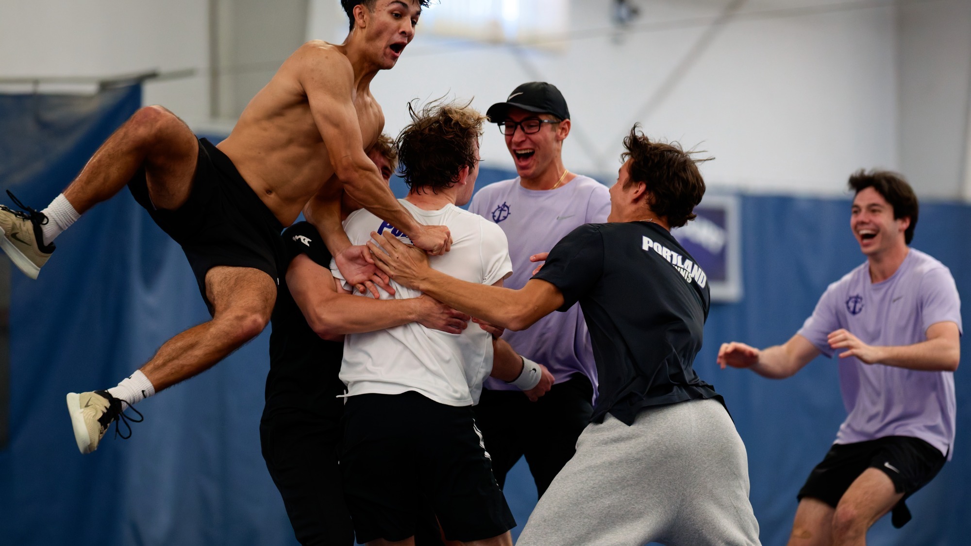 Teammates mob men's tennis player Tannor Binder after providing the match-clinching point against Gonzaga on April 18. 2026.